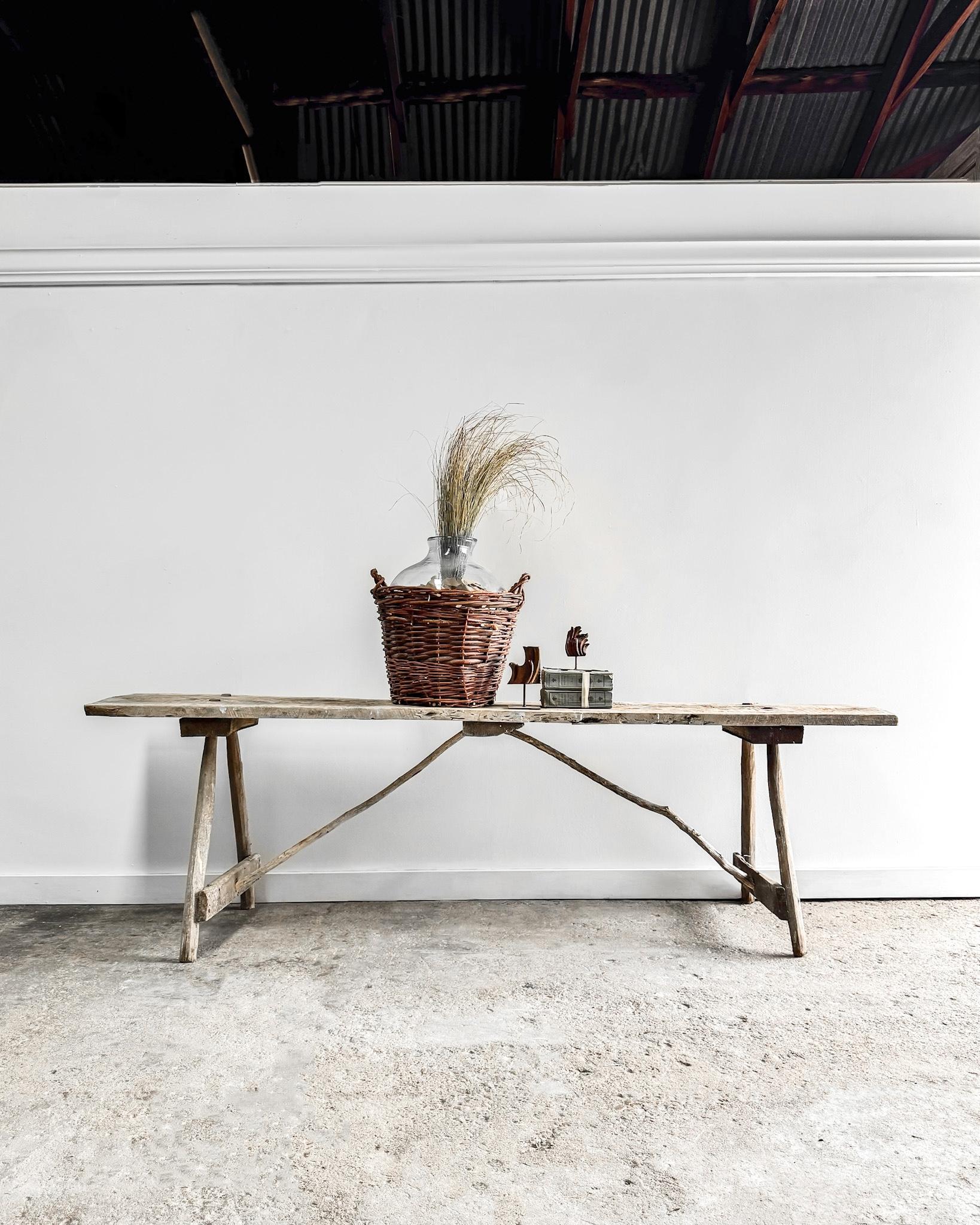 A handcrafted rustic elm washing table featuring a solid board top supported by sturdy A-frame legs complemented by center tree branch supports, adding a touch of natural charm.

Crafted from elm wood, this table exudes a timeless appeal, with its