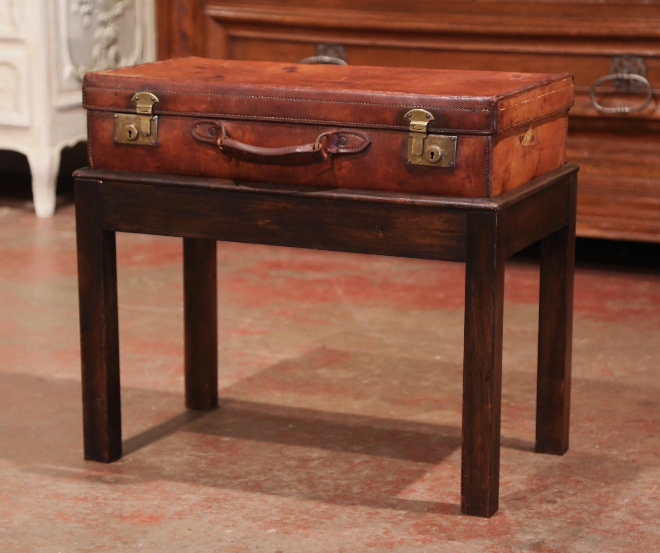 Rectangular in shape, this beautiful suitcase table would make an elegant side or occasional table, crafted in France circa 1890, the leather suitcase with front brass lock mechanism and central handle, is decorated on the top with embossed monogram