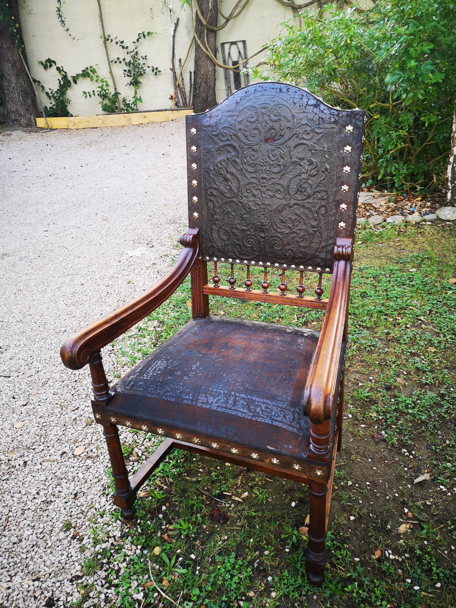 Magnificent Basque regionalist armchair from the end of the 19th century in leather and solid oak. Significant wear of the leather on the seat, beautiful patina. The structure of the seat is magnificently sculpted, it gives this armchair presence