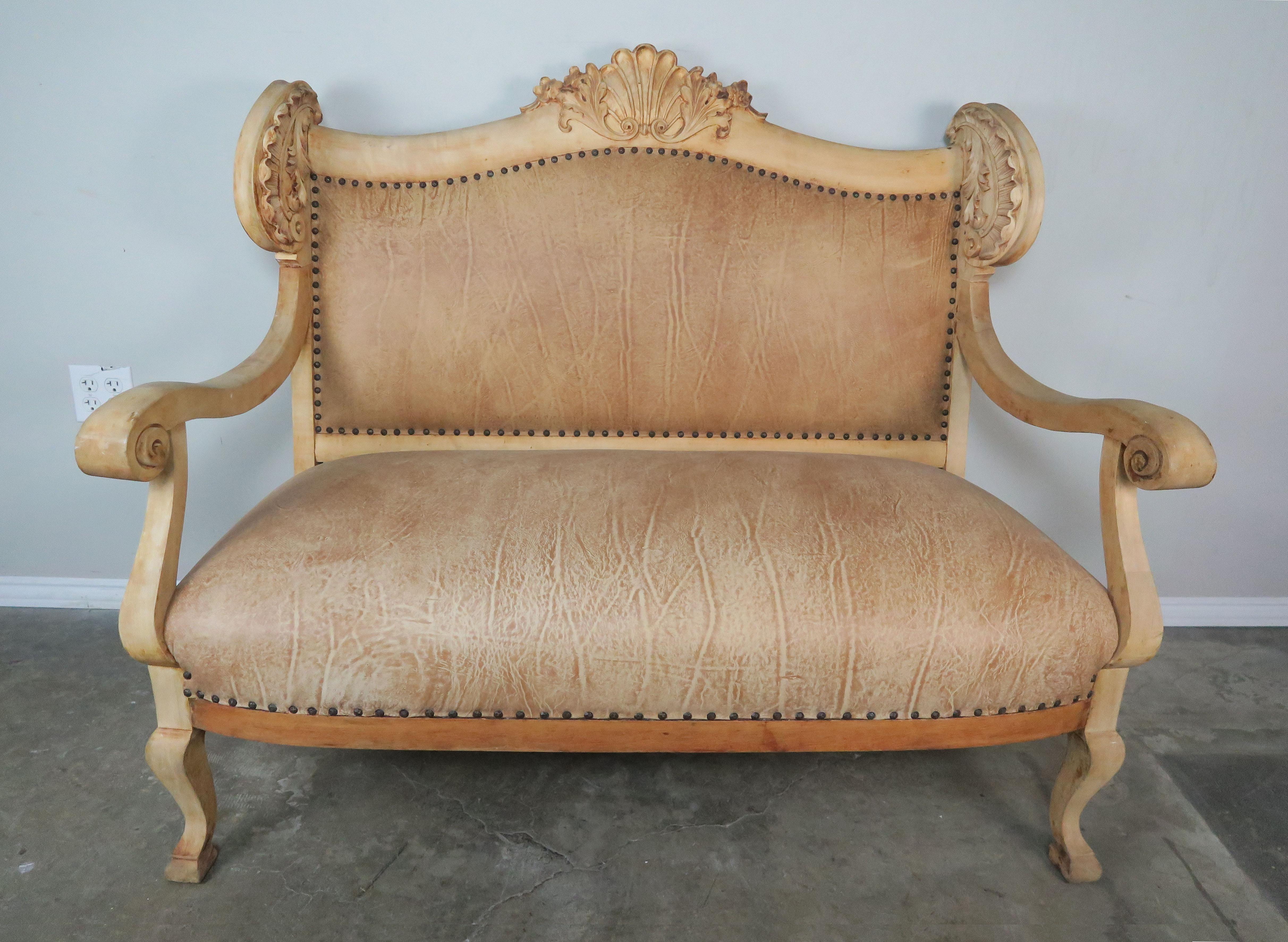 19th century French leather upholstered bleached walnut settee with antique brass nailhead trim detail. Beautiful acanthus leaf carving throughout. The leather is beautifully distressed and in great condition.
Measures: Seat height 20