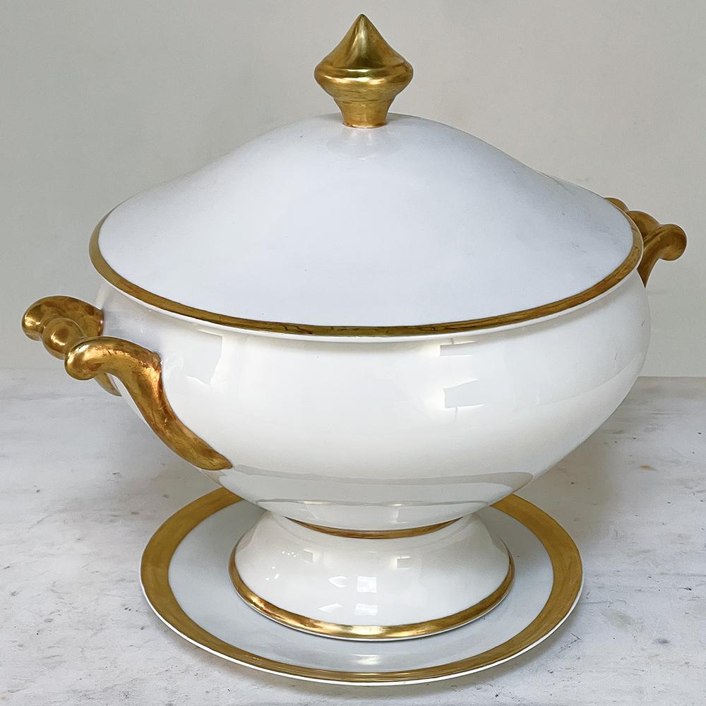 19th century French Limoges hand-painted covered tureen with platter is a stunning example of the exquisite porcelains that were produced during the period by master ceramicists. The stately neoclassical form of the tureen is enhanced by the painted