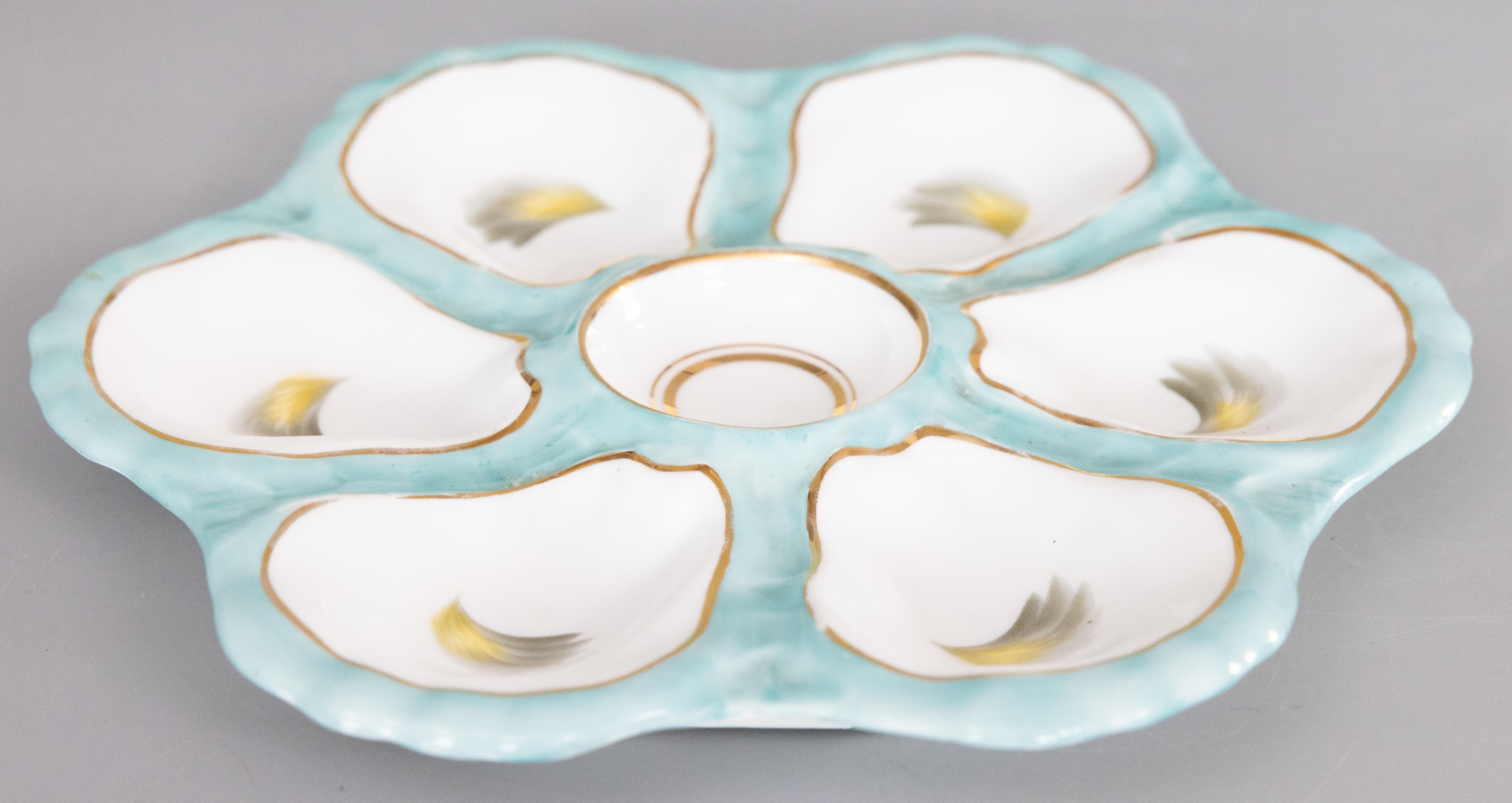 A gorgeous antique 19th-Century French porcelain oyster plate. Hand painted and numbered on reverse. Attributed to Limoges, France, circa 1880. This fine quality oyster plate has six wells, lovely turquoise accents, and gilt details. It displays