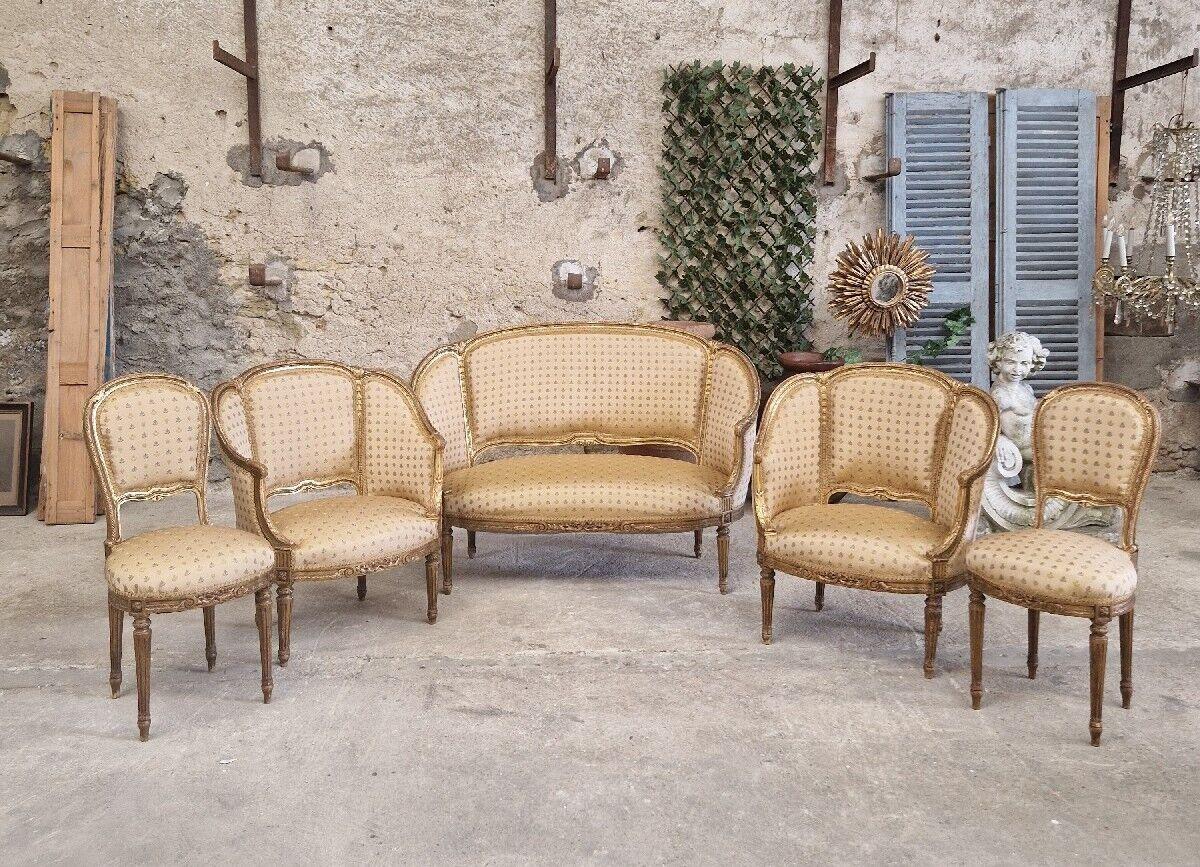 Cet élégant ensemble de salon du XIXe siècle présente un style Louis XV glamour avec des marques Rocaille complexes sur des cadres en bois doré. L'ensemble comprend un canapé et des chaises rembourrées en soie luxueuse, pouvant accueillir jusqu'à 6