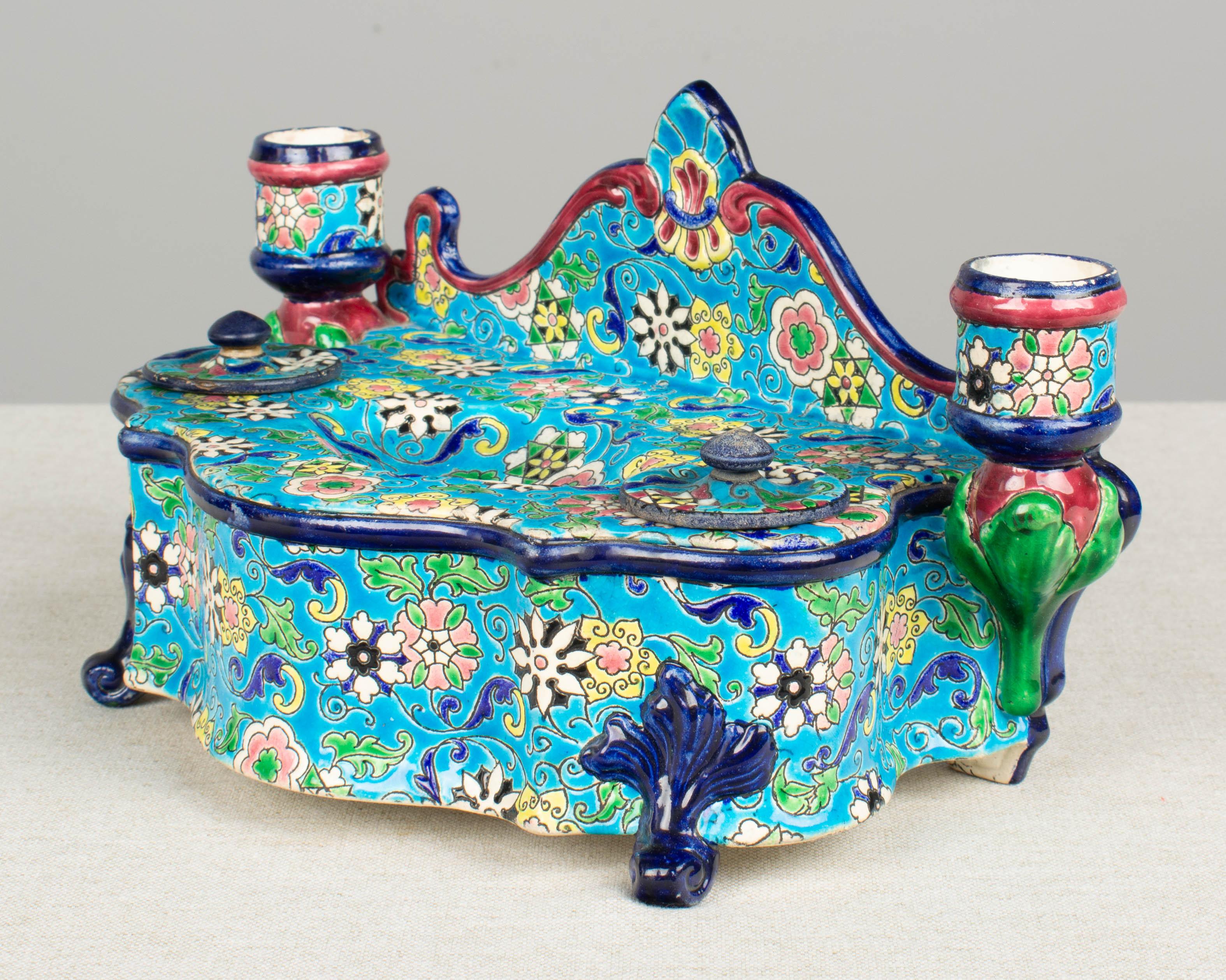 A 19th century French Longwy ceramic desk set with inkwells and candle holders. Beautiful cloisonné enamel floral design with vibrant blue pink, rose, green and yellow on bright turquoise ground. There are no ink pot inserts. Wear to the enamel,