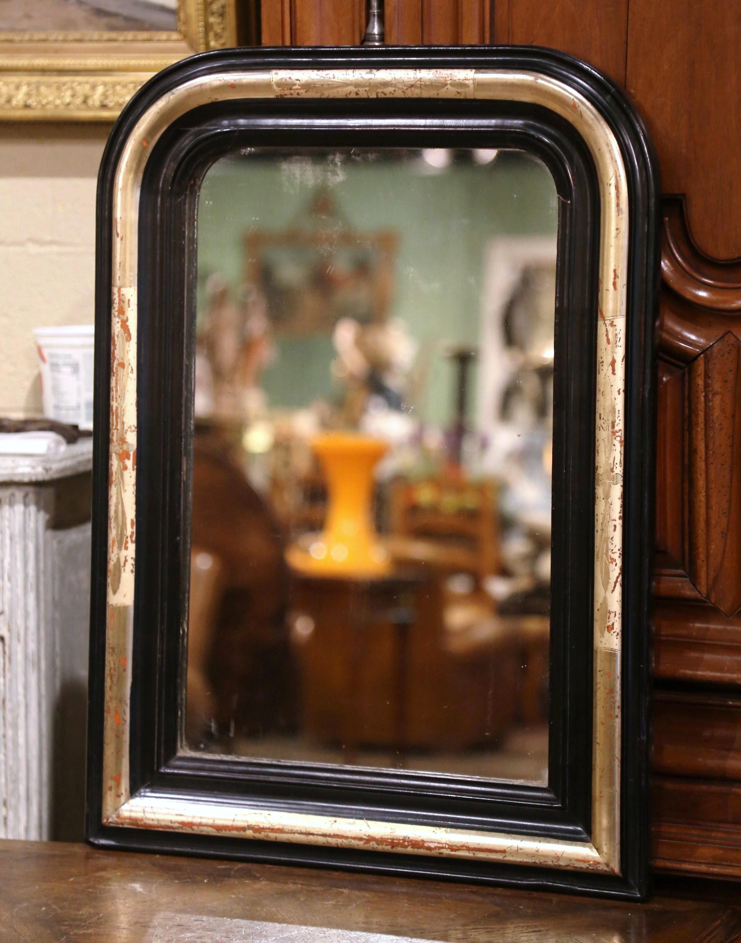 Décorez une salle d'eau ou une entrée avec cet élégant miroir mural ancien à deux tons. Fabriqué en France vers 1860, ce miroir rectangulaire présente un bandeau de feuilles d'or orné d'un discret motif floral et feuillagé gravé, entre deux bordures