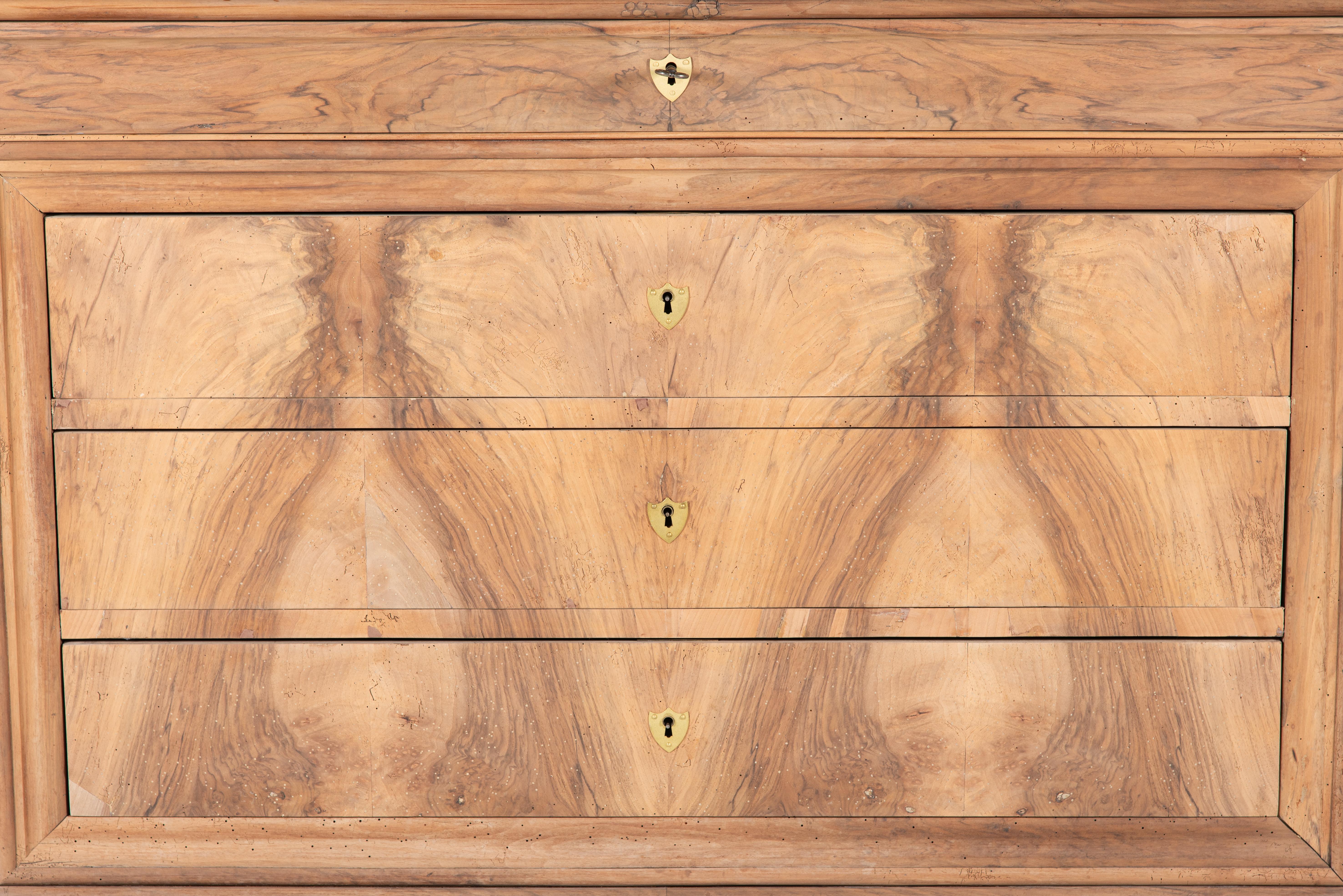 This 19th Century French Louis Philippe Burl Walnut Commode is a striking piece that reflects the elegance and simplicity of the Louis Philippe era. With four spacious drawers, this commode offers ample storage while showcasing exquisite