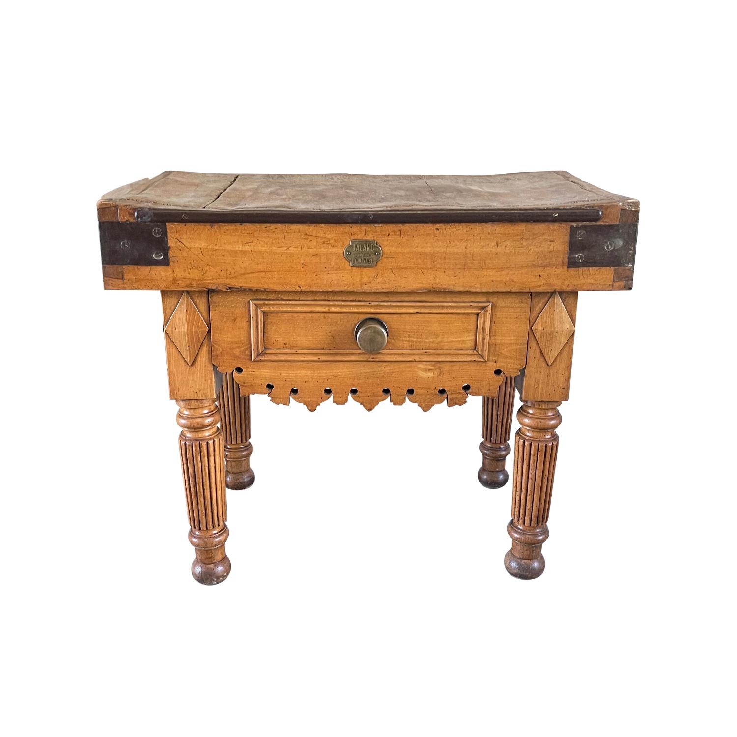 A late 19th Century, antique French Louis Philippe Butcher Block table made of hand crafted Beechwood, in good condition. Heavy wood corpus with Rhombus shaped detail on the fluted legs with a scalloped decorative apron and original brass hardware.