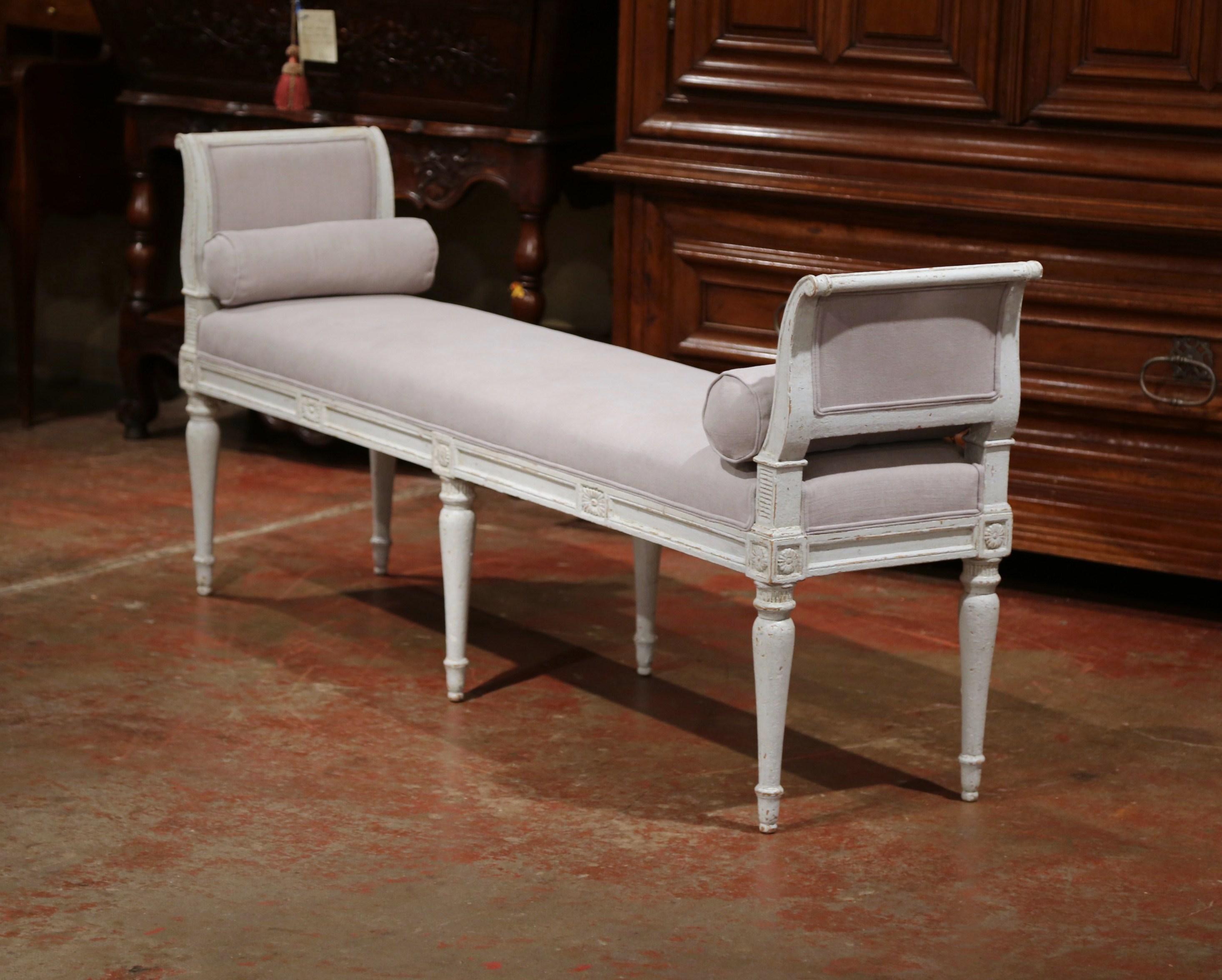 This elegant, antique banquette was crafted in France, circa 1880. The long and narrow bench features six turned and tapered legs, a curved back at each end and hand carved medallion motifs around the apron. The seat has been reupholstered with a