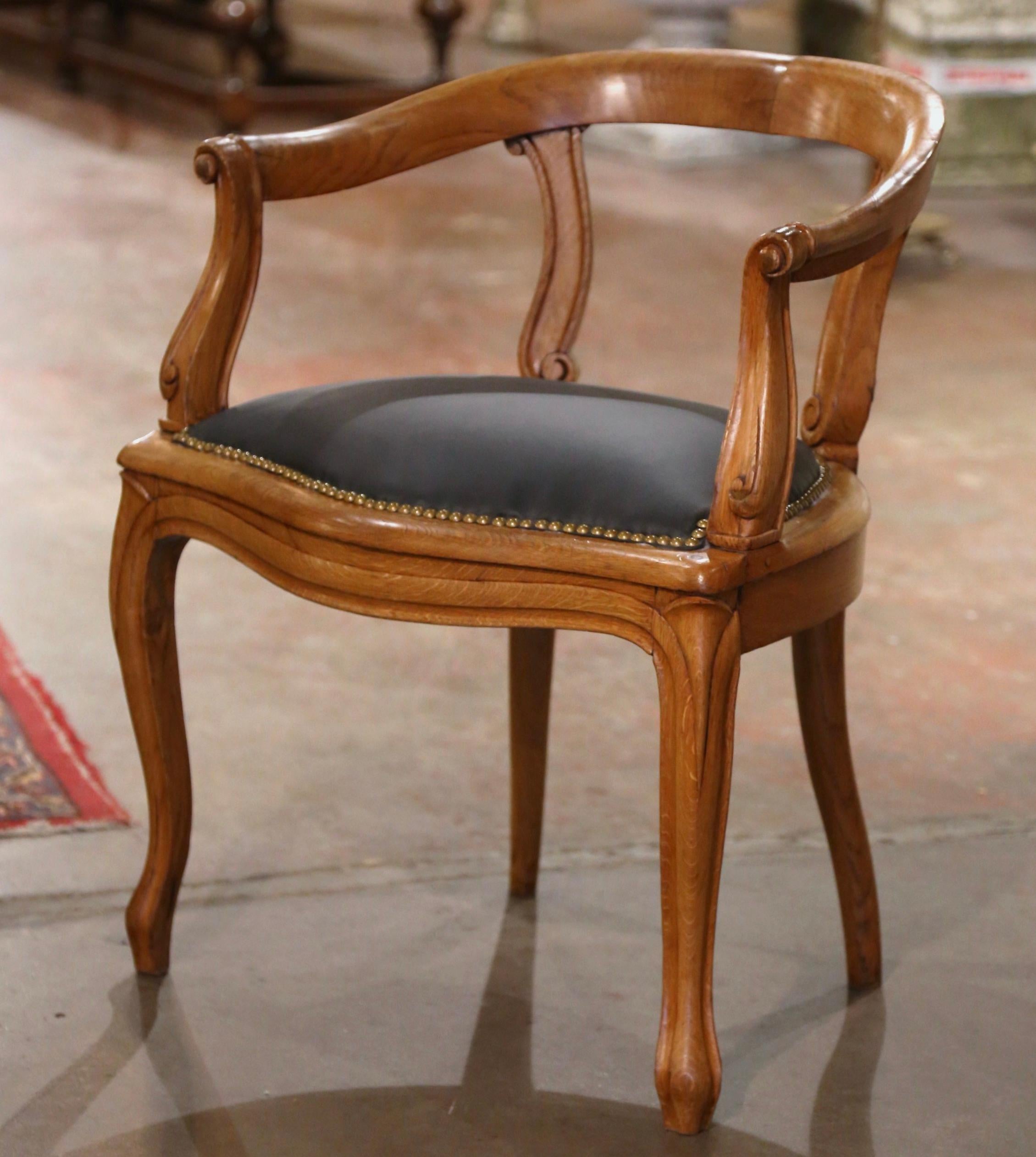 The sophisticated antique armchair would make an elegant yet subtle statement behind a man or woman's desk. Crafted in France circa 1880 and made of elm, the carved armchair sits on front cabriole legs; the chair features a rounded and curved back,