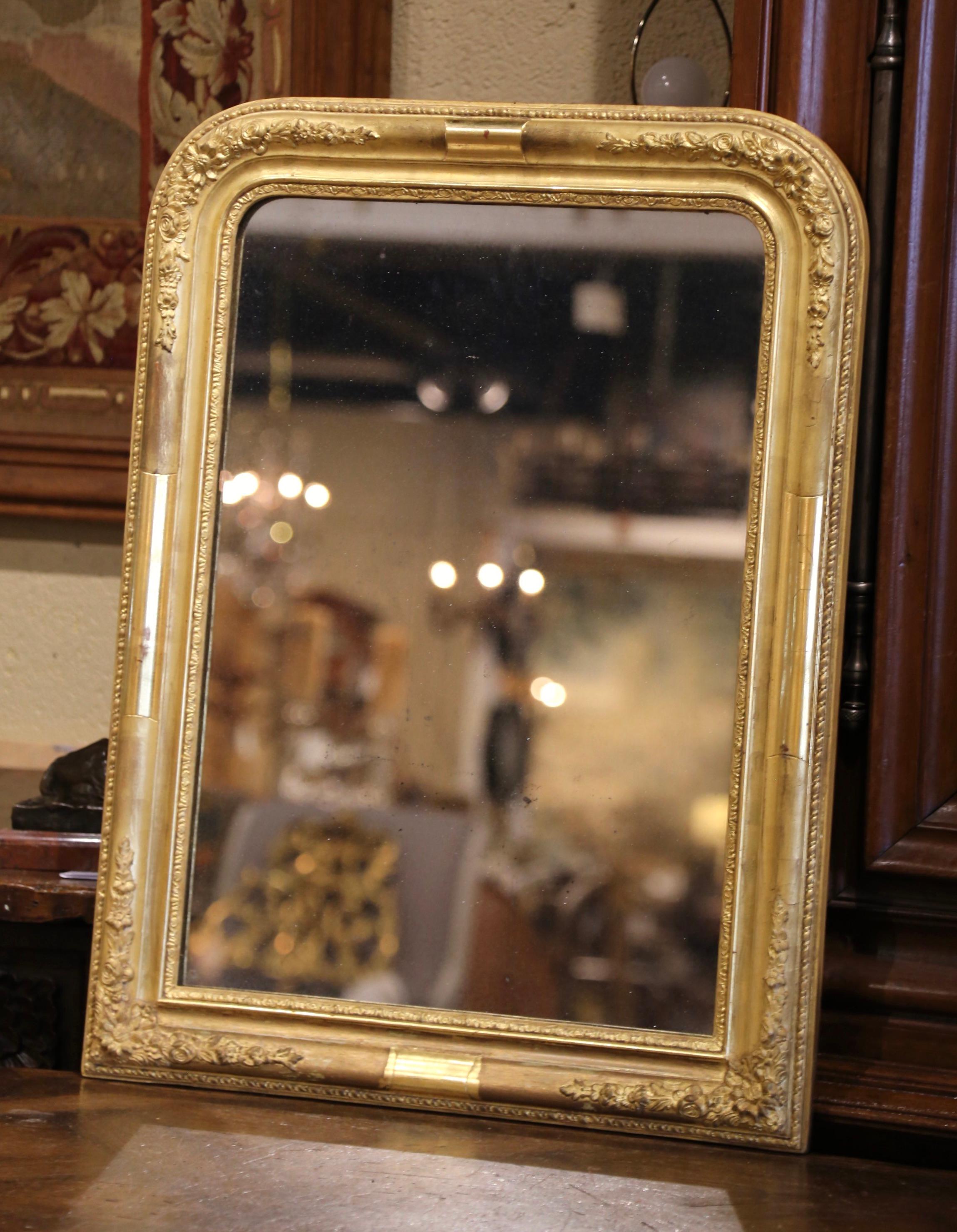 Decorate a powder room with this elegant, antique Louis Philippe gilt mirror. Crafted in France, circa 1860, this rectangular mirror has traditional lines with round corners. The carved frame is embellished with floral and foliage motifs in high