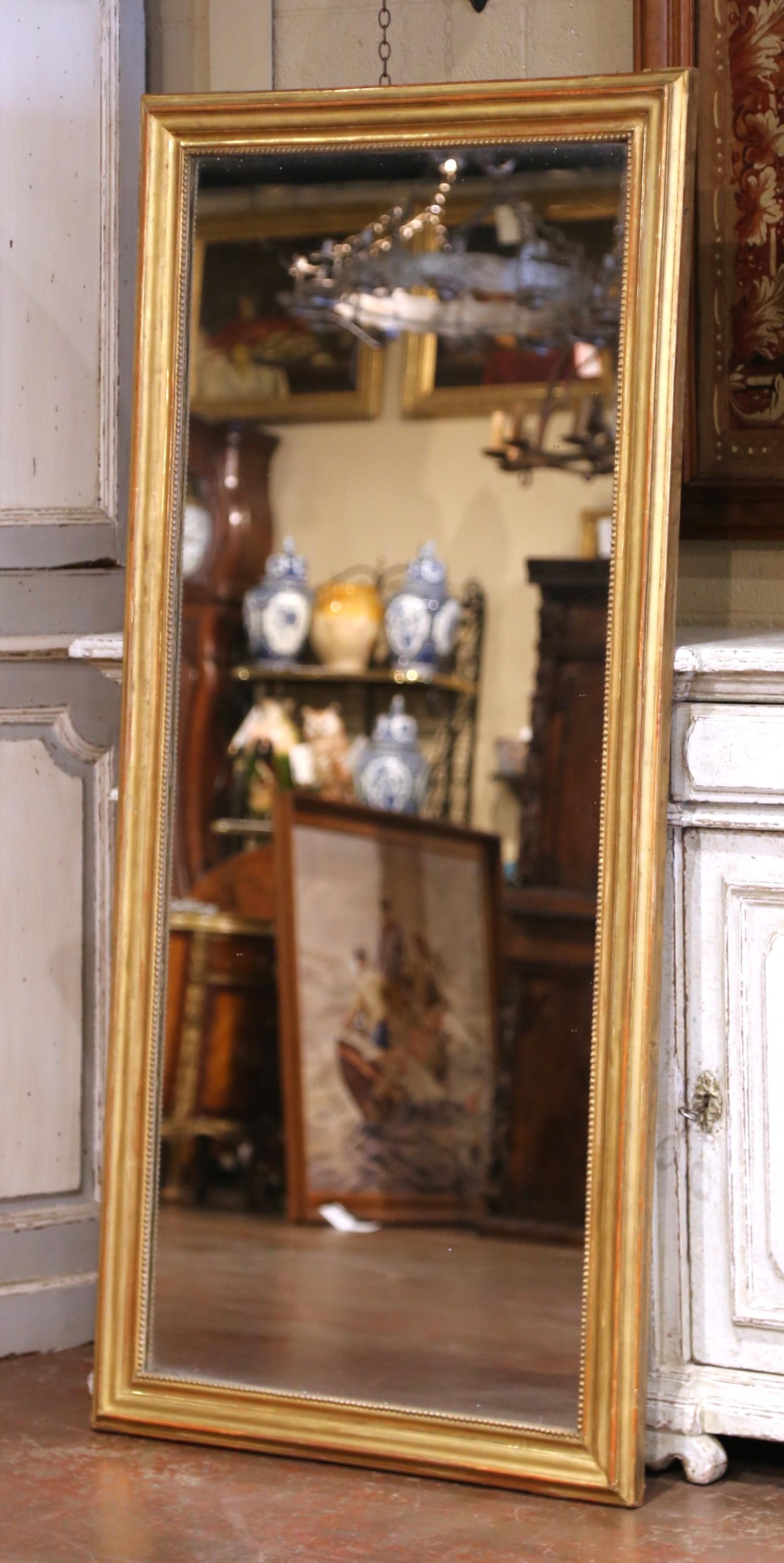 Dieser elegante Spiegel aus dem 19. Jahrhundert wurde um 1860 in Frankreich gefertigt und spiegelt die raffinierte Schlichtheit des Louis-Philippe-Stils wider. Der hohe, rechteckige Rahmen ist aus Holz gefertigt und mit dem ursprünglichen Blattgold