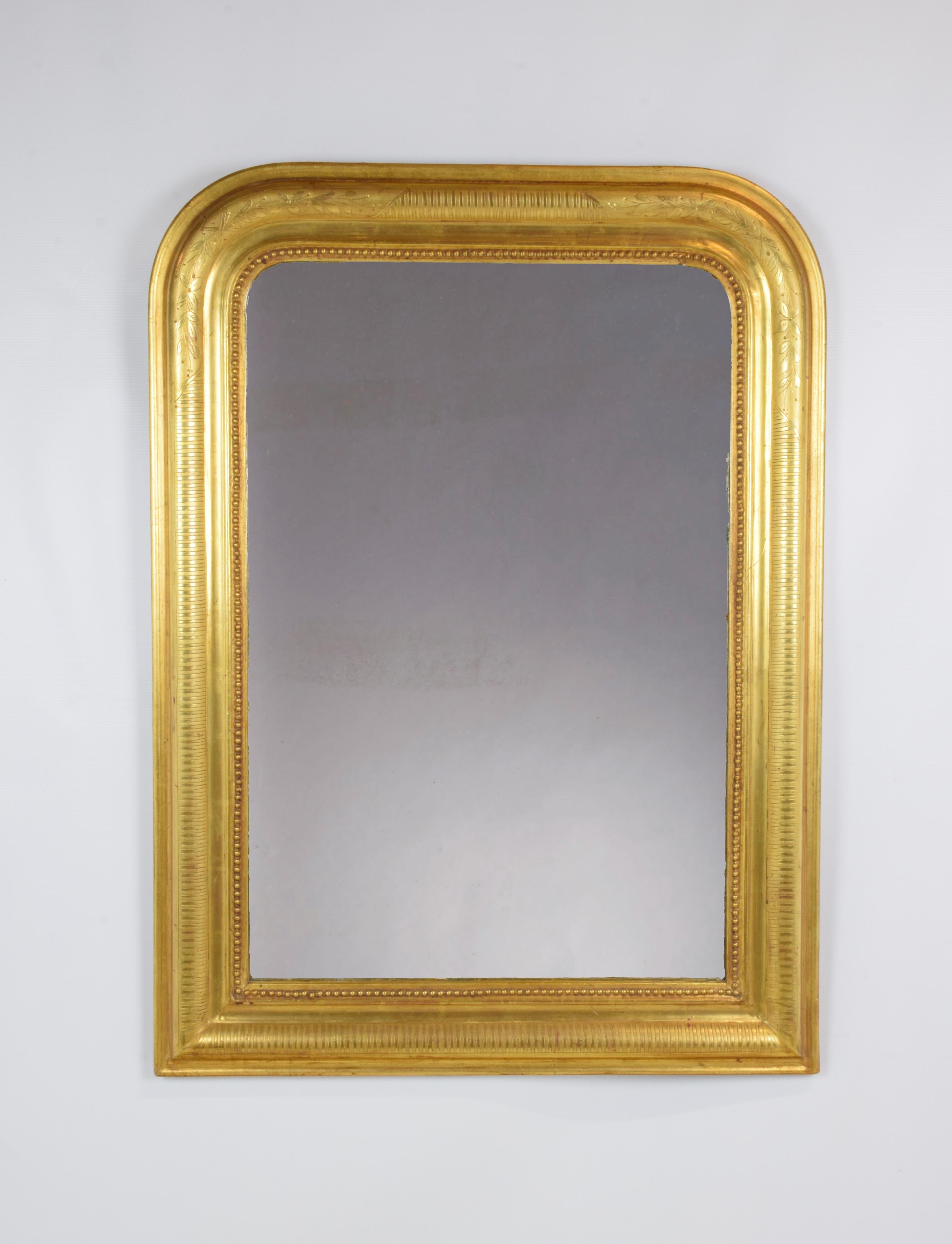 Der antike Spiegel wurde um 1880 in Frankreich hergestellt und hat traditionelle Linien mit abgerundeten Ecken. Der Rahmen ist mit reinem Blattgold auf einem gravierten Motiv aus matten und glänzenden Streifen vergoldet. In die abgerundeten Teile