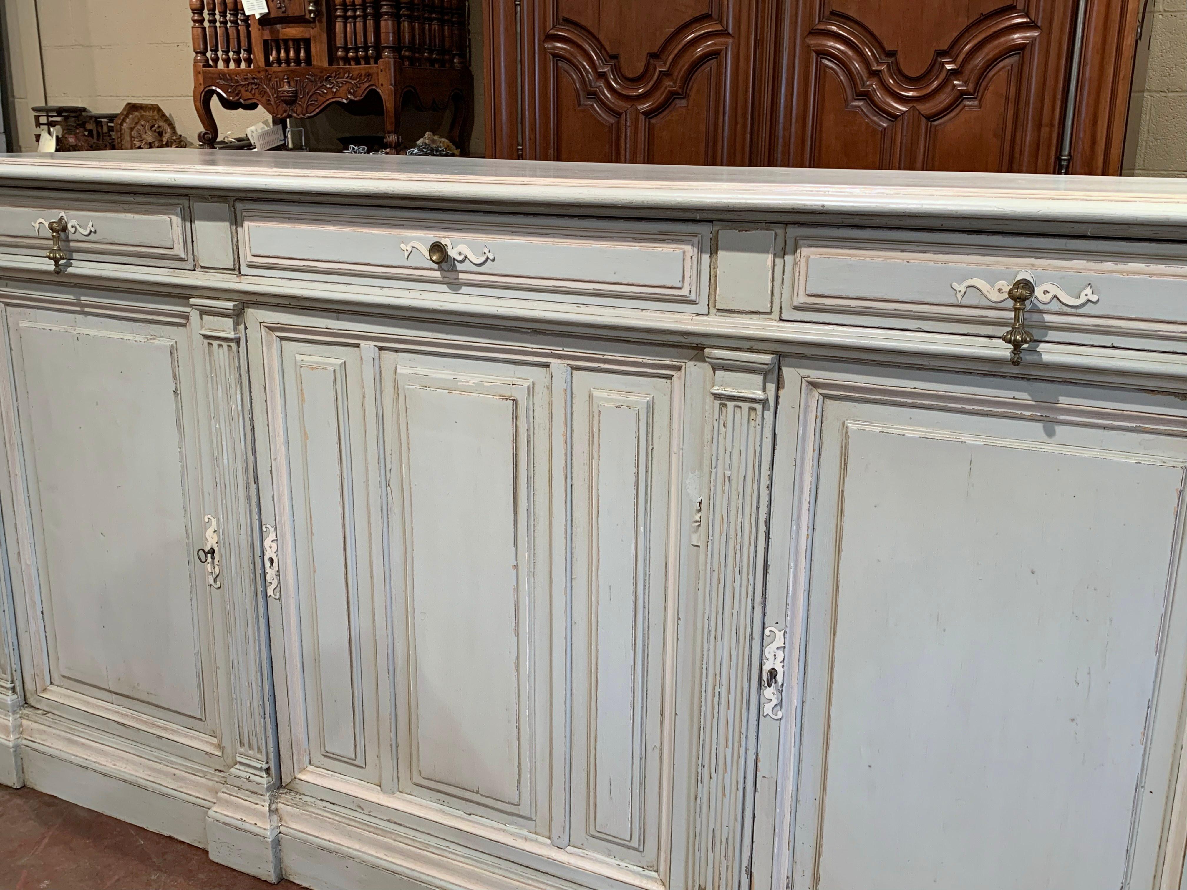 Decorate a dining room with this large, Louis Philippe style antique server enfilade. Crafted in France, circa 1860, the long, painted cabinet stands on a plinth base, and features three doors and three drawers across the front. The inside is