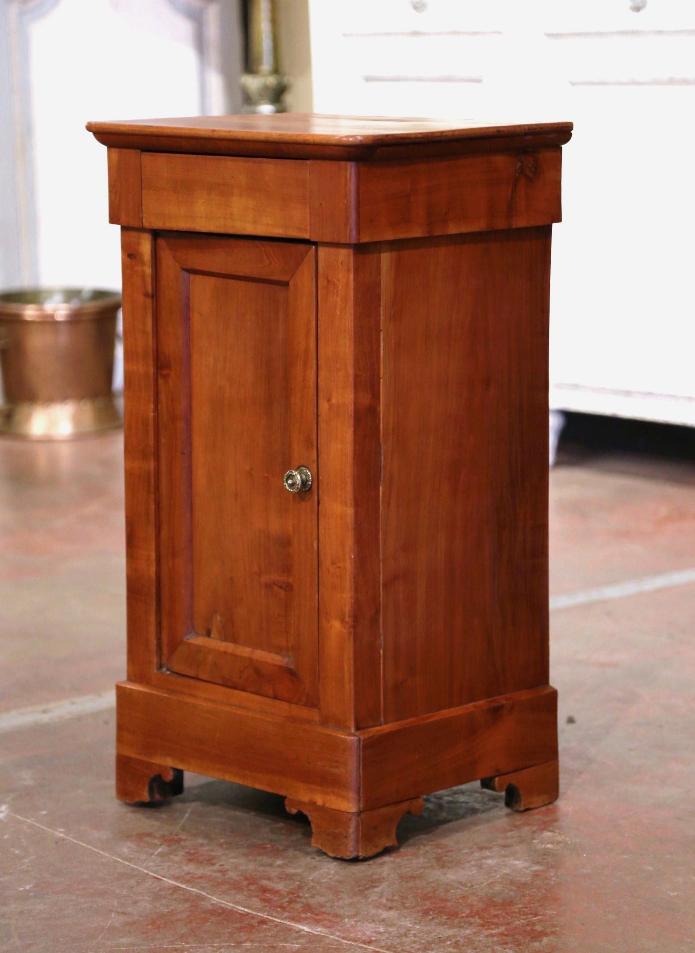 This elegant antique nightstand was crafted in France, circa 1890. The fruit wood cabinet stands on bracket feet over a straight plinth; it features a single frieze drawer over a large door decorated with recessed panel. The cabinet opens to inside