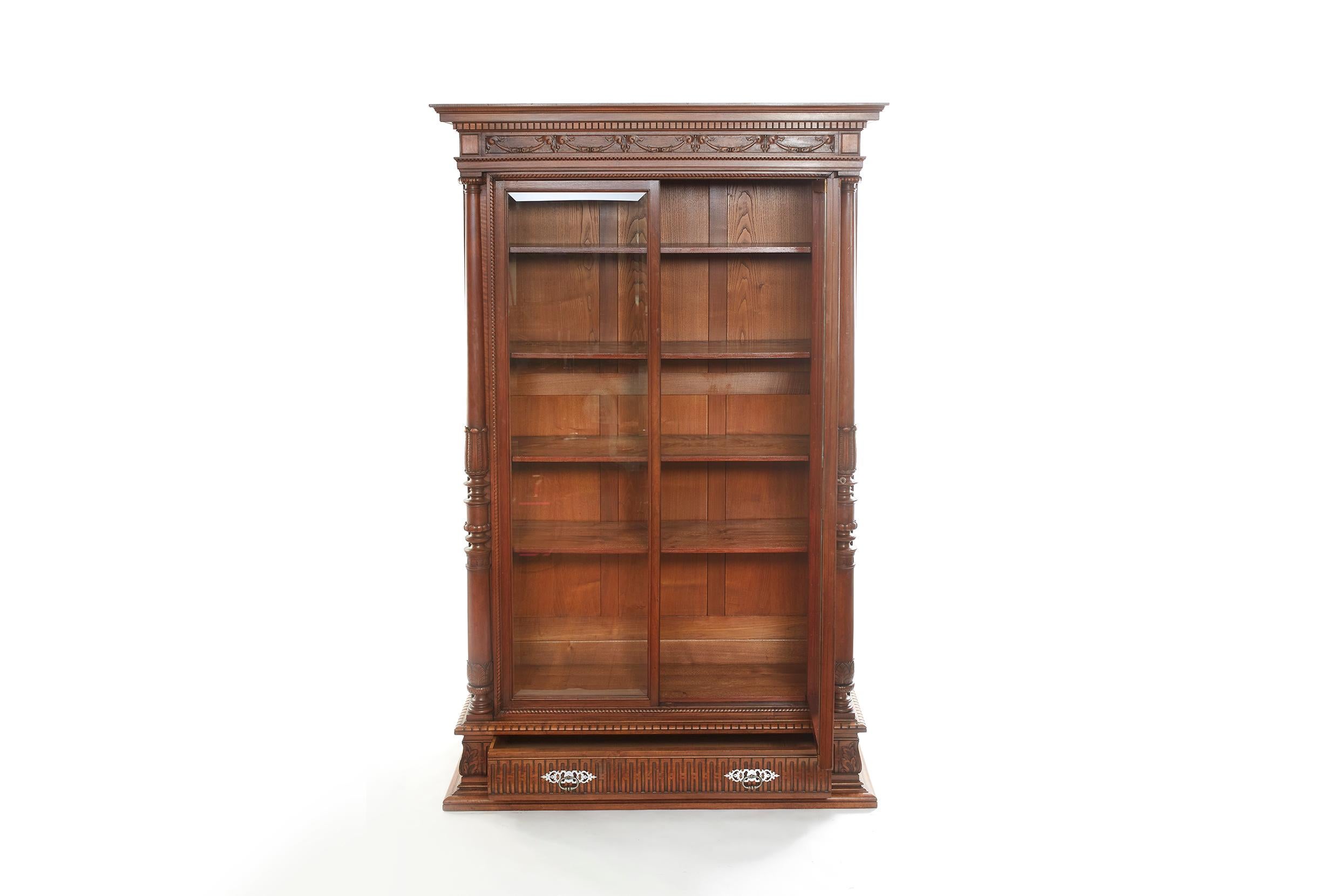 Mid 19th century French Chaleyssin Freres Louis Philippe style hand carved walnut two doors display cabinet / bookcase with exterior hand carved design details. The display cabinet / bookcase is in great antique condition. Maker's mark signed. Minor