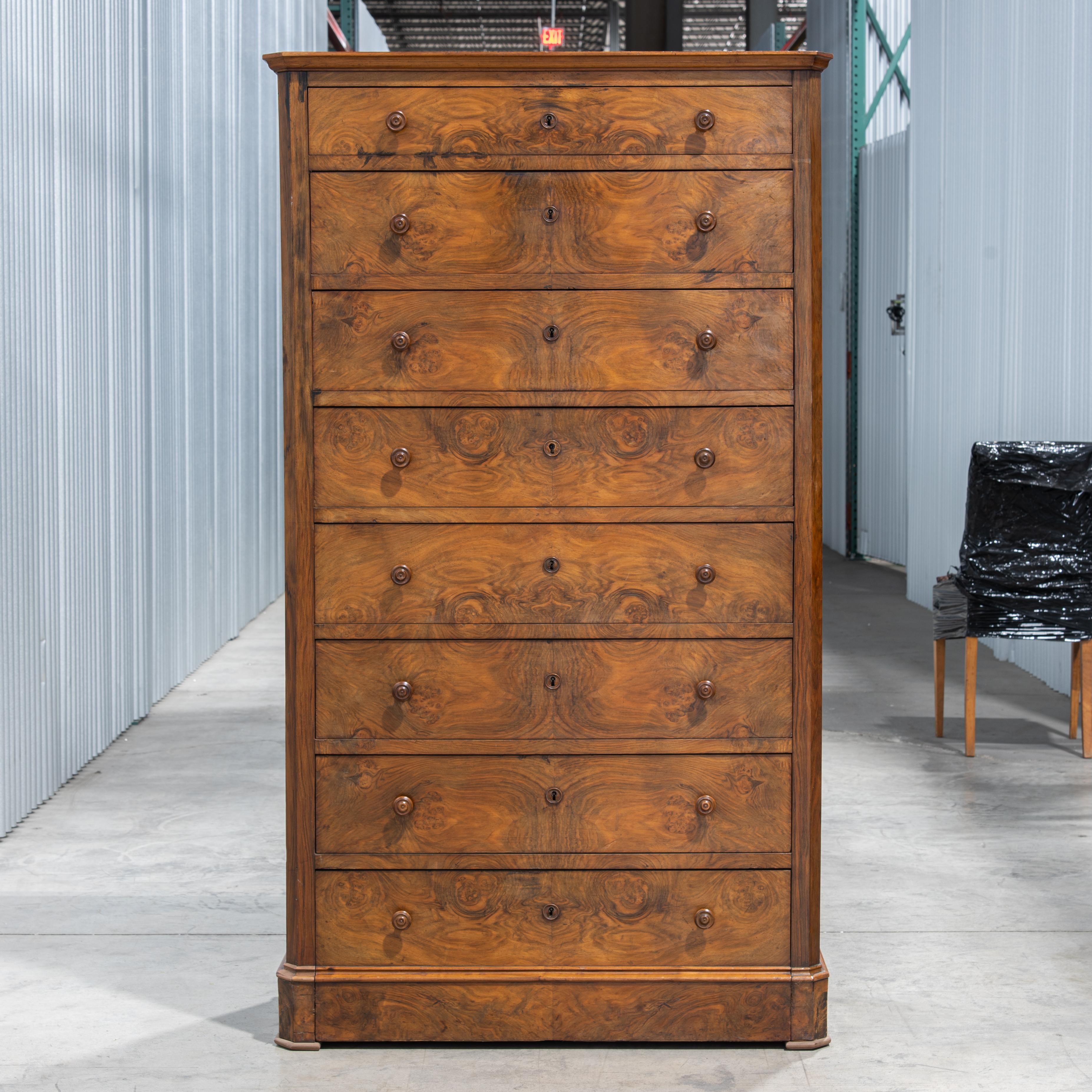 Voici un magnifique chiffonnier Louis Philippe du 19e siècle, orné d'un placage de ronce de noyer. Cette pièce élégante incarne la sophistication et le savoir-faire supérieur de l'époque Louis Philippe, connue pour ses éléments de design à la fois