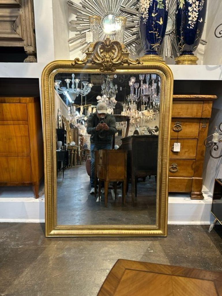 Fine quality 19th century French Louis Philippe giltwood mirror with a crest at the top. The frame has a line pattern and there is a beaded inner border. Very elegant!