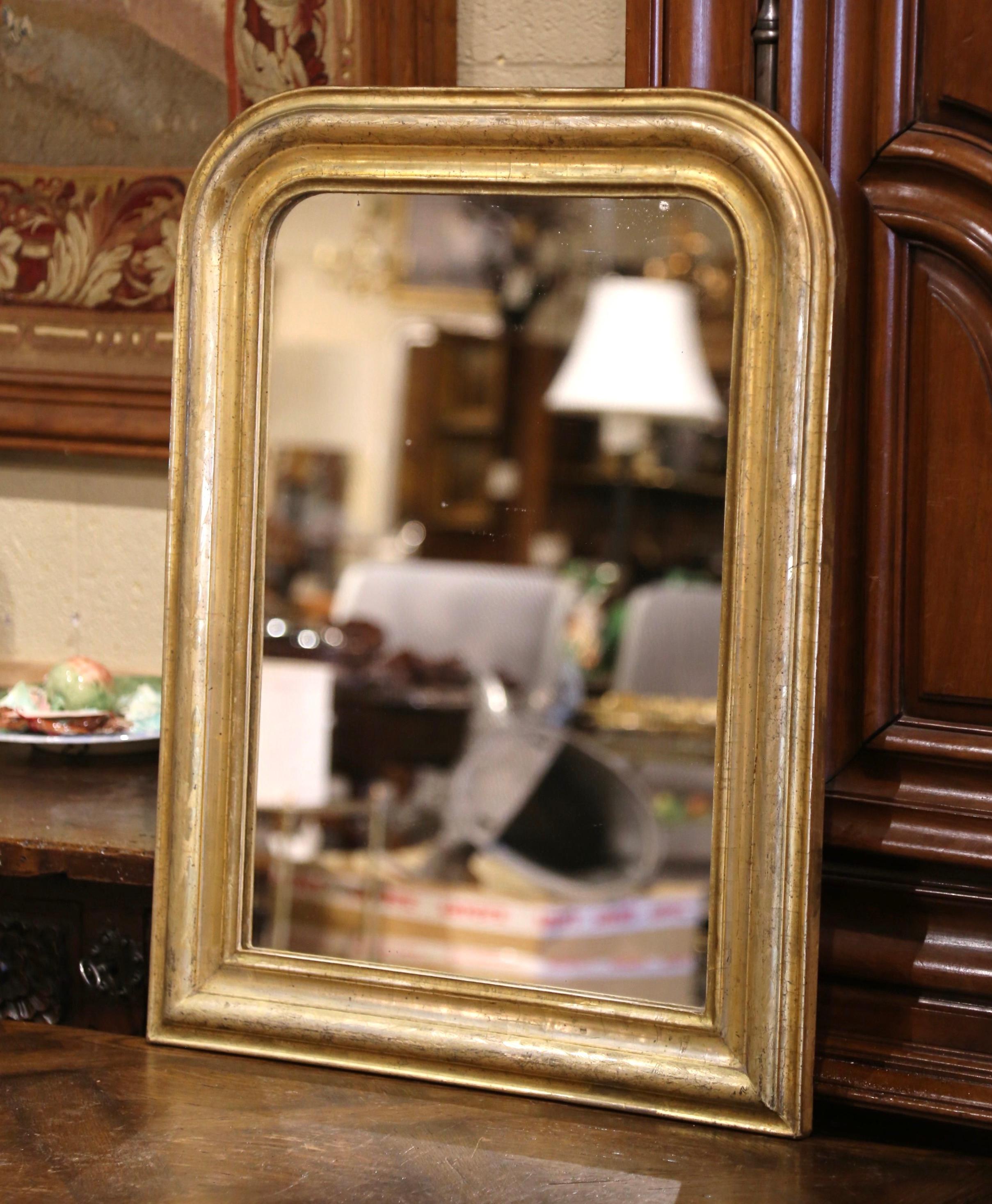 Decorate a powder room or a hallway with this antique gilt wood wall mirror. Crafted in the Burgundy region of France circa 1870, the mirror has traditional lines with rounded corners; the rectangular wall decor is embellished with a discrete