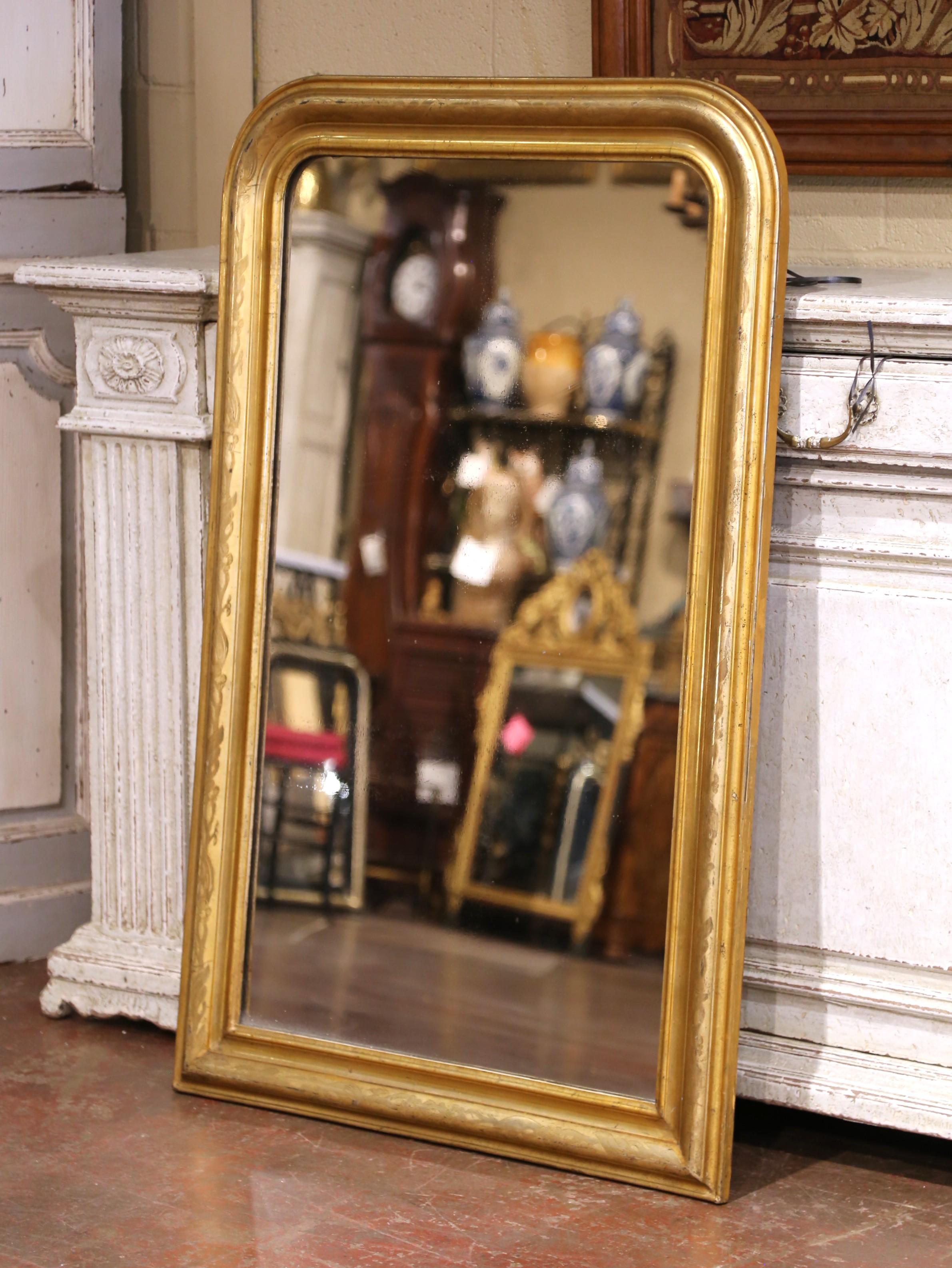 Questo elegante specchio da parete del XIX secolo è stato realizzato in Francia intorno al 1860, nell'intramontabile stile Louis Philippe. Di forma rettangolare con gli angoli superiori arrotondati, lo specchio è incorniciato in legno dorato