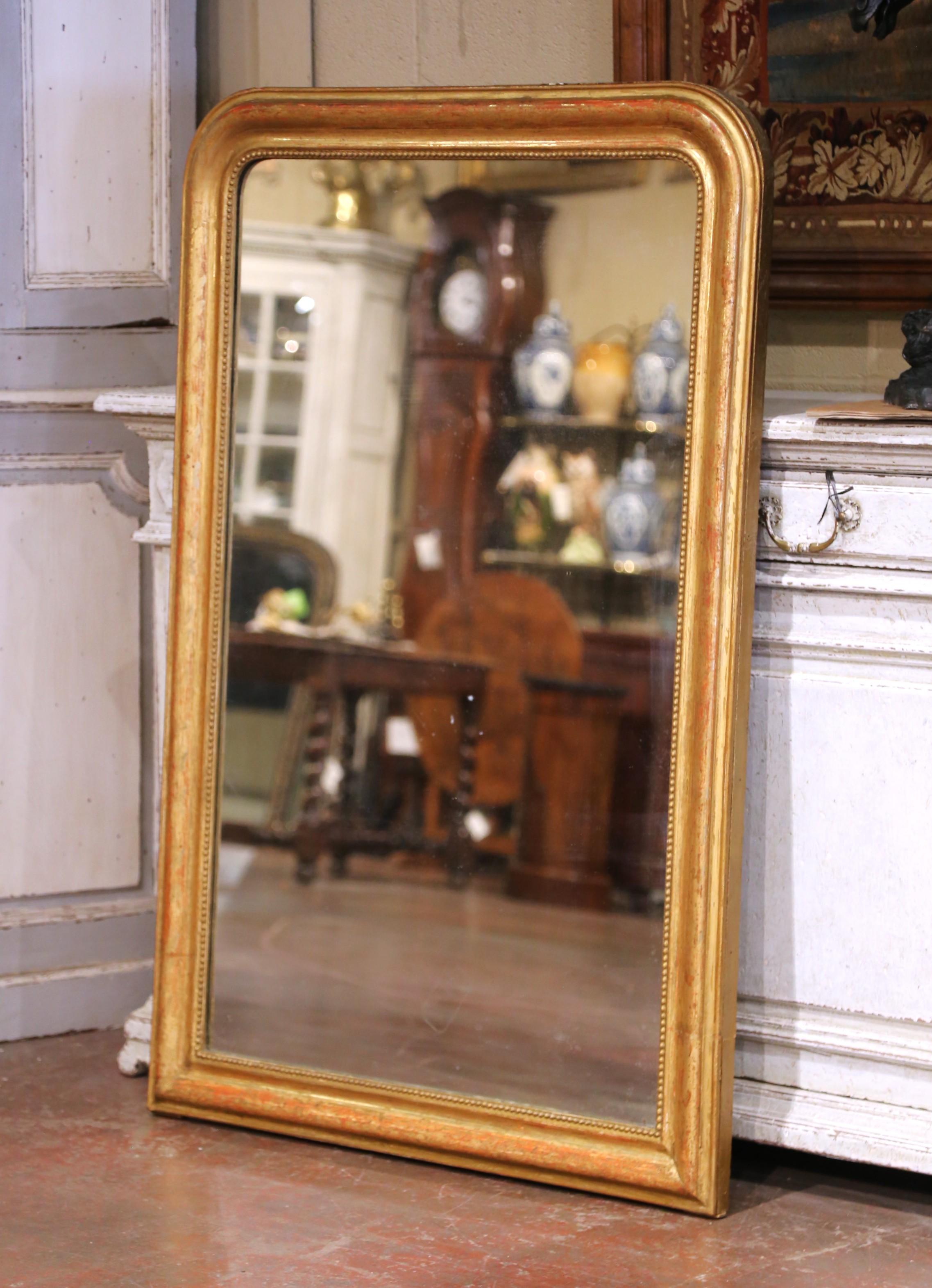 Fabricado en la región francesa de Borgo�ña hacia 1860, el gran espejo dorado antiguo tiene líneas tradicionales con esquinas redondeadas; el grueso marco rectangular está decorado con discretos motivos florales grabados por todas partes y adornado