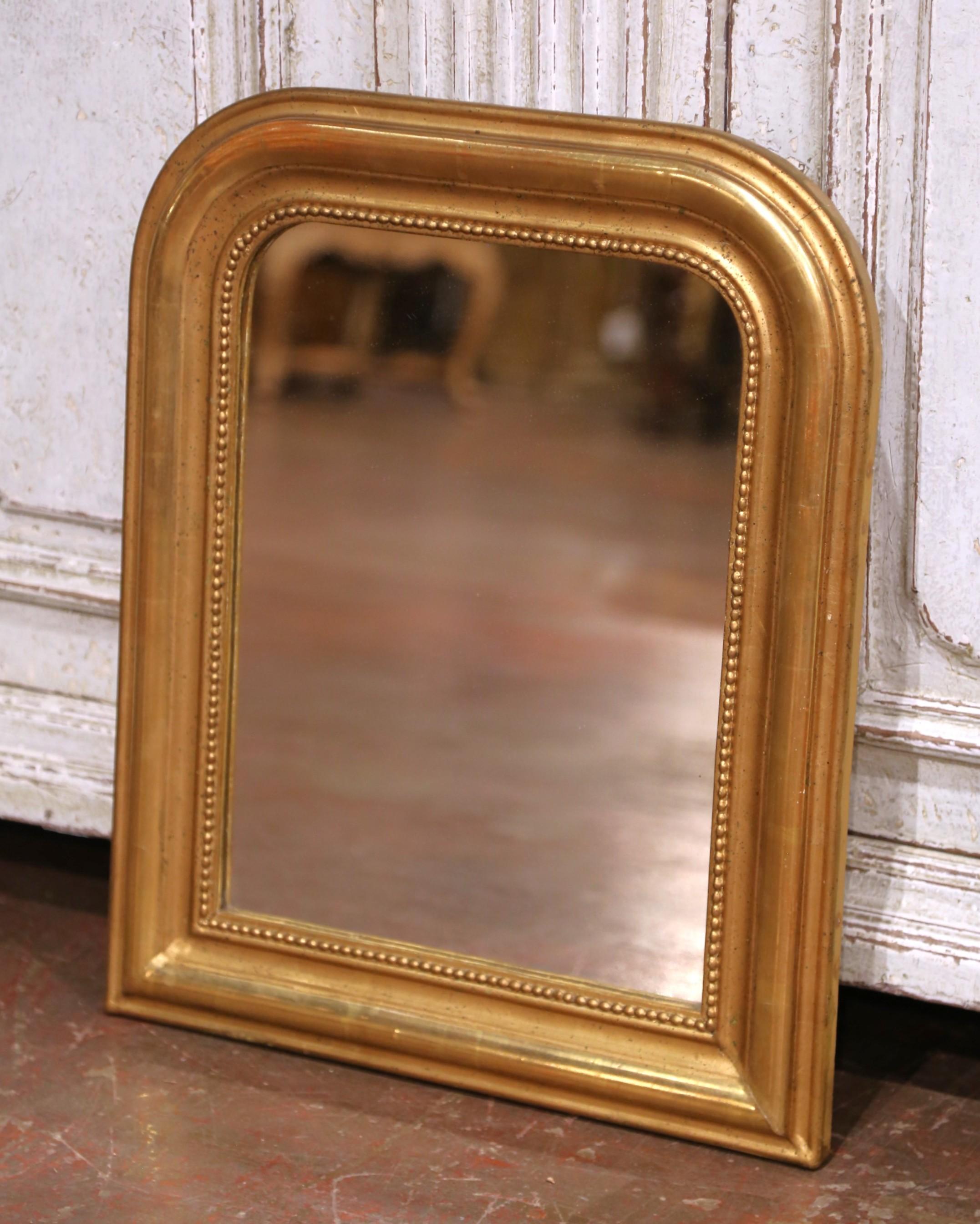 Decorate a powder room or a hallway with this antique gilt wood wall mirror. Crafted in the Burgundy region of France circa 1870, the petite mirror has traditional lines with rounded corners; the rectangular wall decor is embellished with discrete