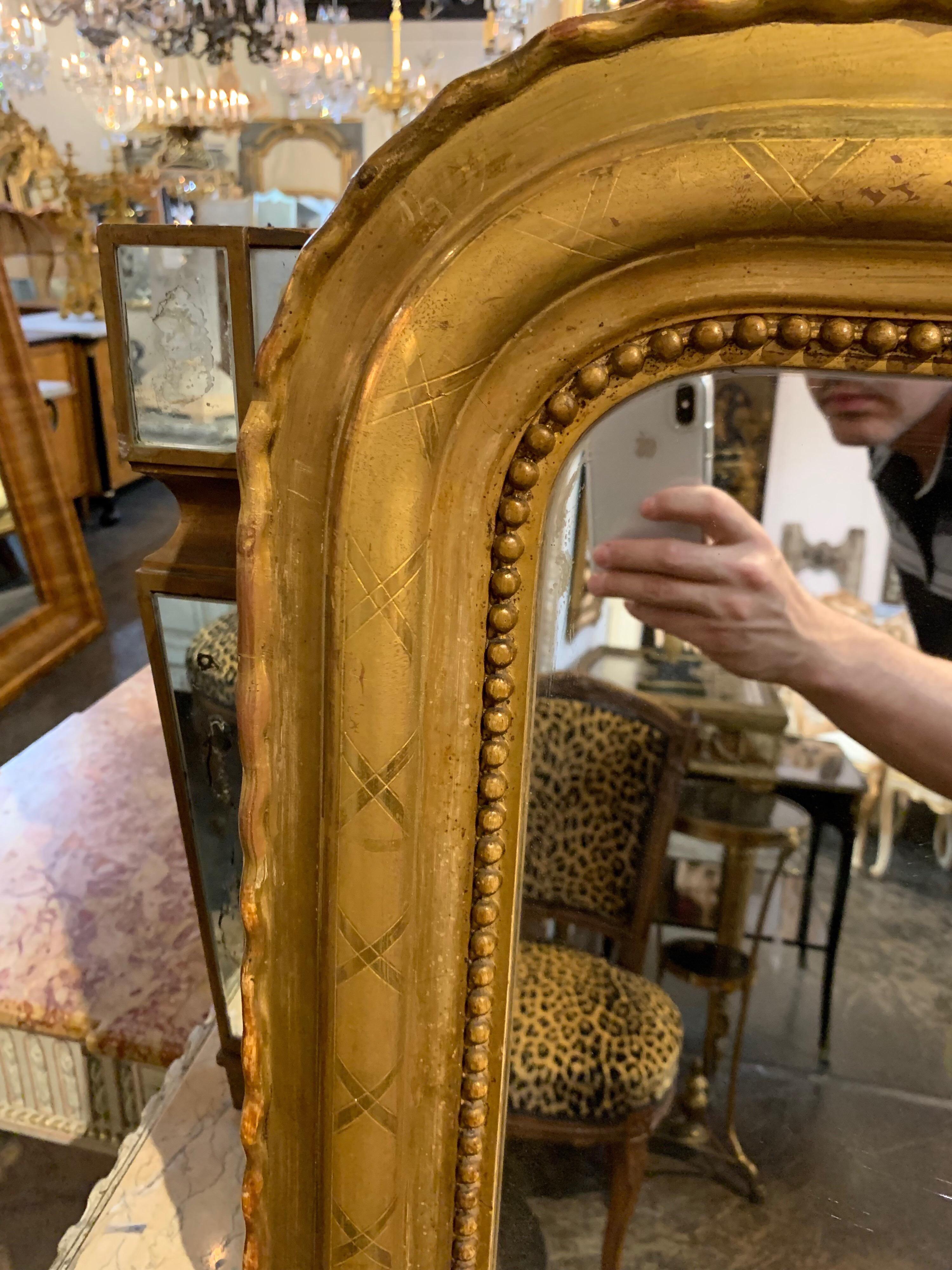 Very lovely 19th century French Louis Philippe gold gilt mirror. Has an X pattern and nice beaded detail and beautiful scalloped edge. Original wood on the back of the mirror. Makes an impressive statement in a fine home.