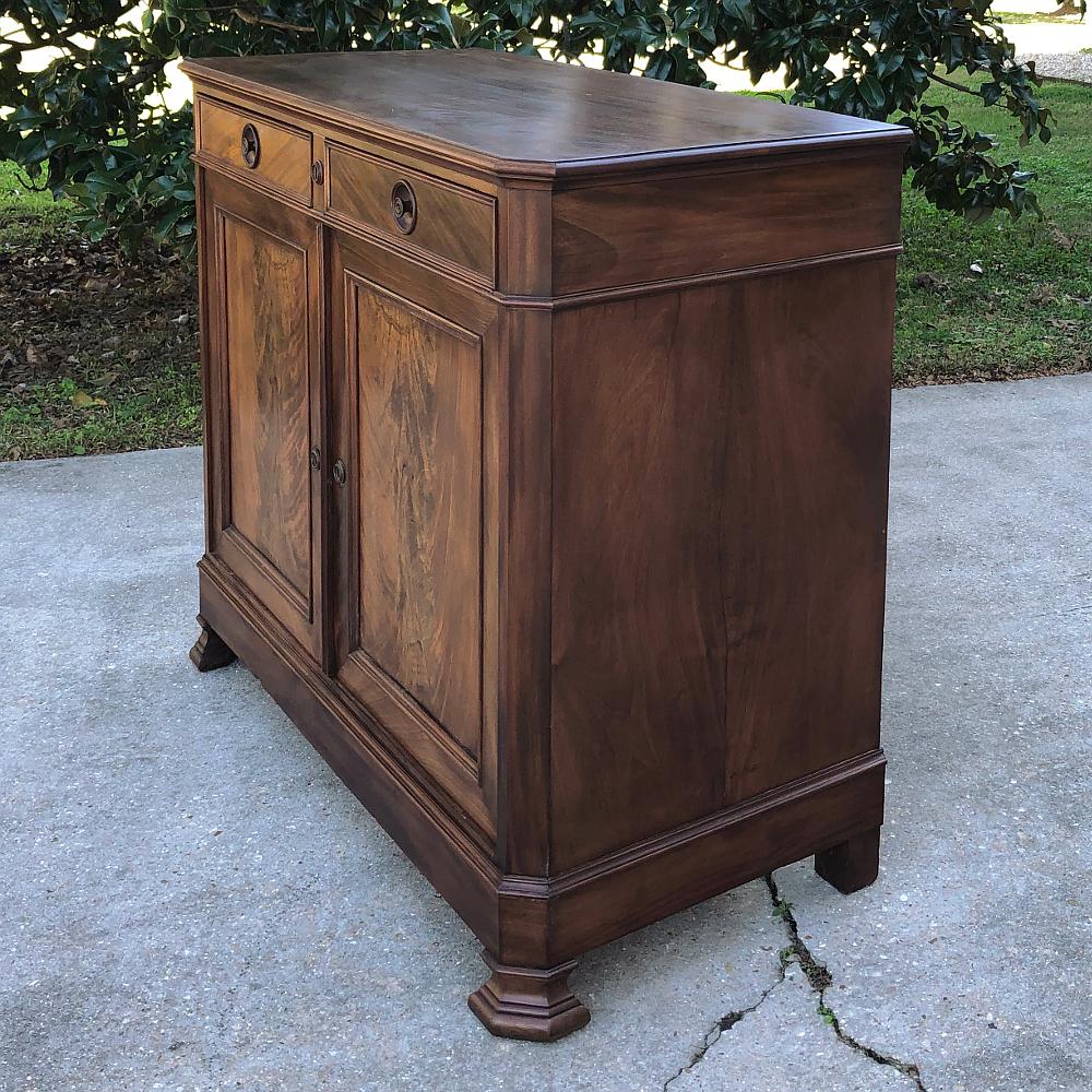 19th century French Louis Philippe mahogany buffet represents the epitome of the style, with a tailored, clean architecture that draws attention to the sheer natural beauty of the exotic imported flame mahogany that adorns the cabinet door panels.