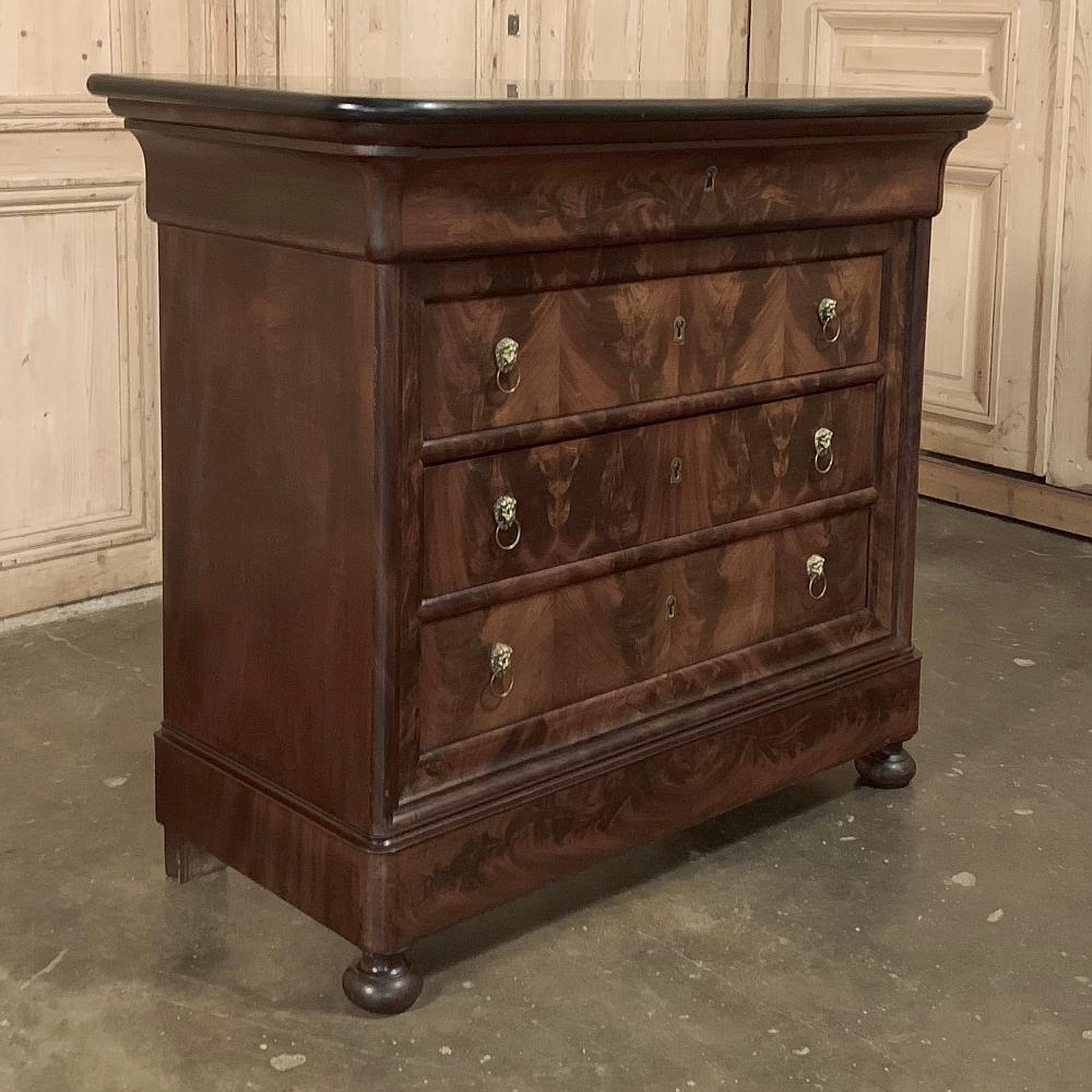 19th century French Louis Philippe marble top commode reflects the tailored look that was the choice of the court during the period. Utilizing exotic flame mahogany from the Americas to create visual interest, it is otherwise architecturally pure.