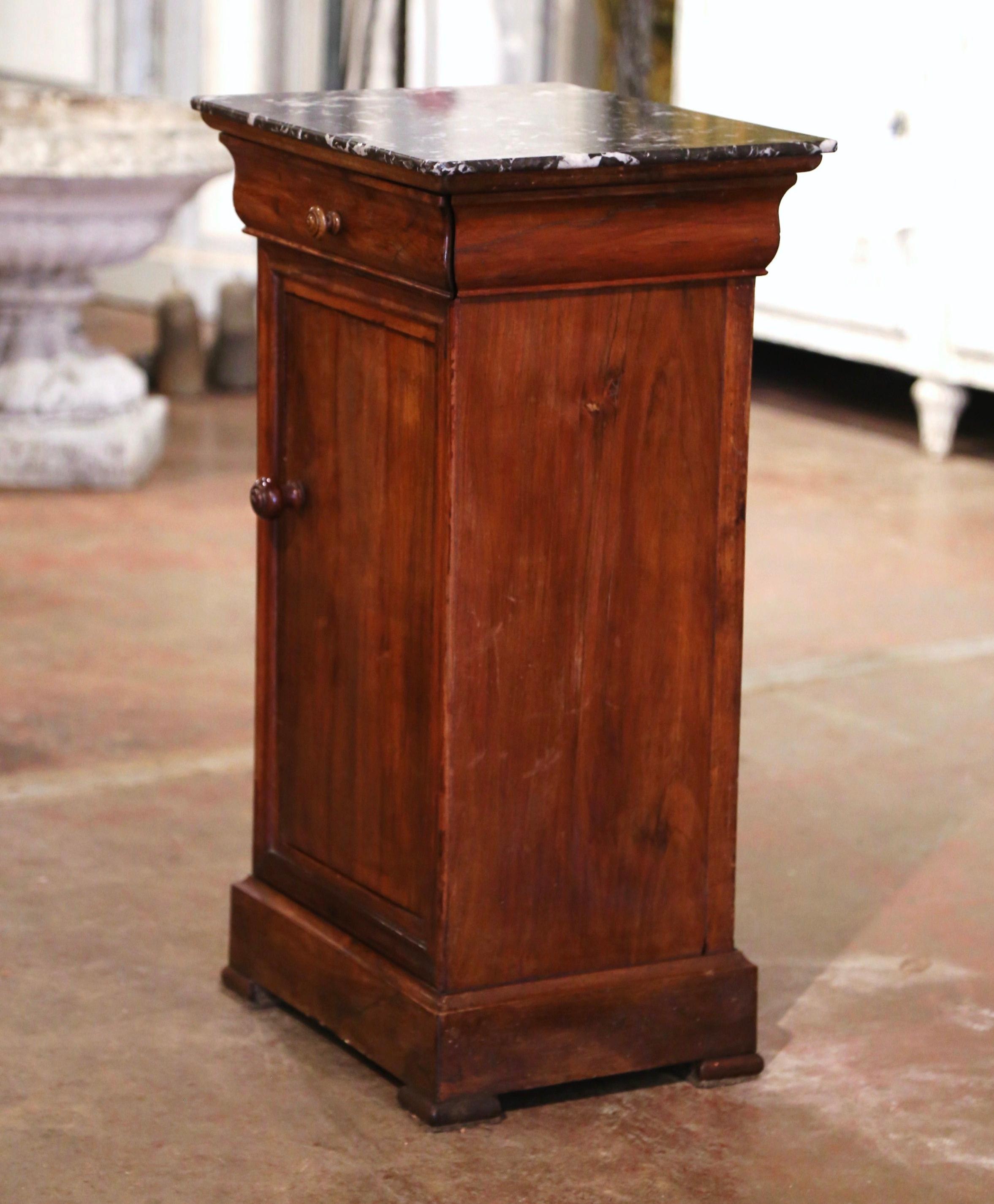 This elegant antique nightstand was crafted in France, circa 1890. The traditional fruit wood cabinet sits on bracket feet over a wide bottom plinth; it is fitted with a single drawer dressed with a wooden knob, over a front door also dressed with a