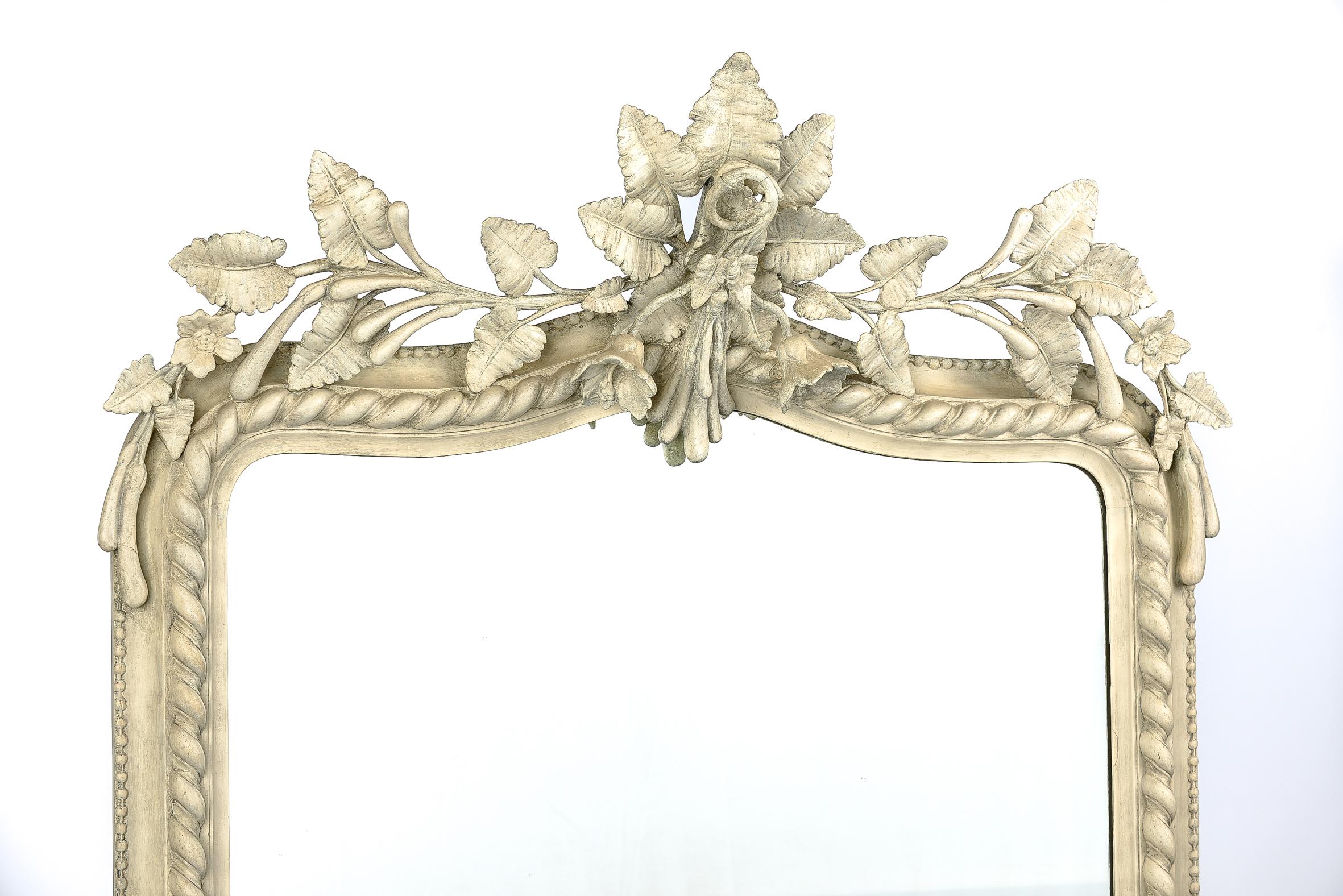 Questo bellissimo specchio Antique French Louis Philippe ha uno stemma decorato sulla parte superiore e ornamenti floreali in entrambi gli angoli inferiori. 
La montatura a forma di gadroon ha una bordatura di perle che circonda il bordo esterno.