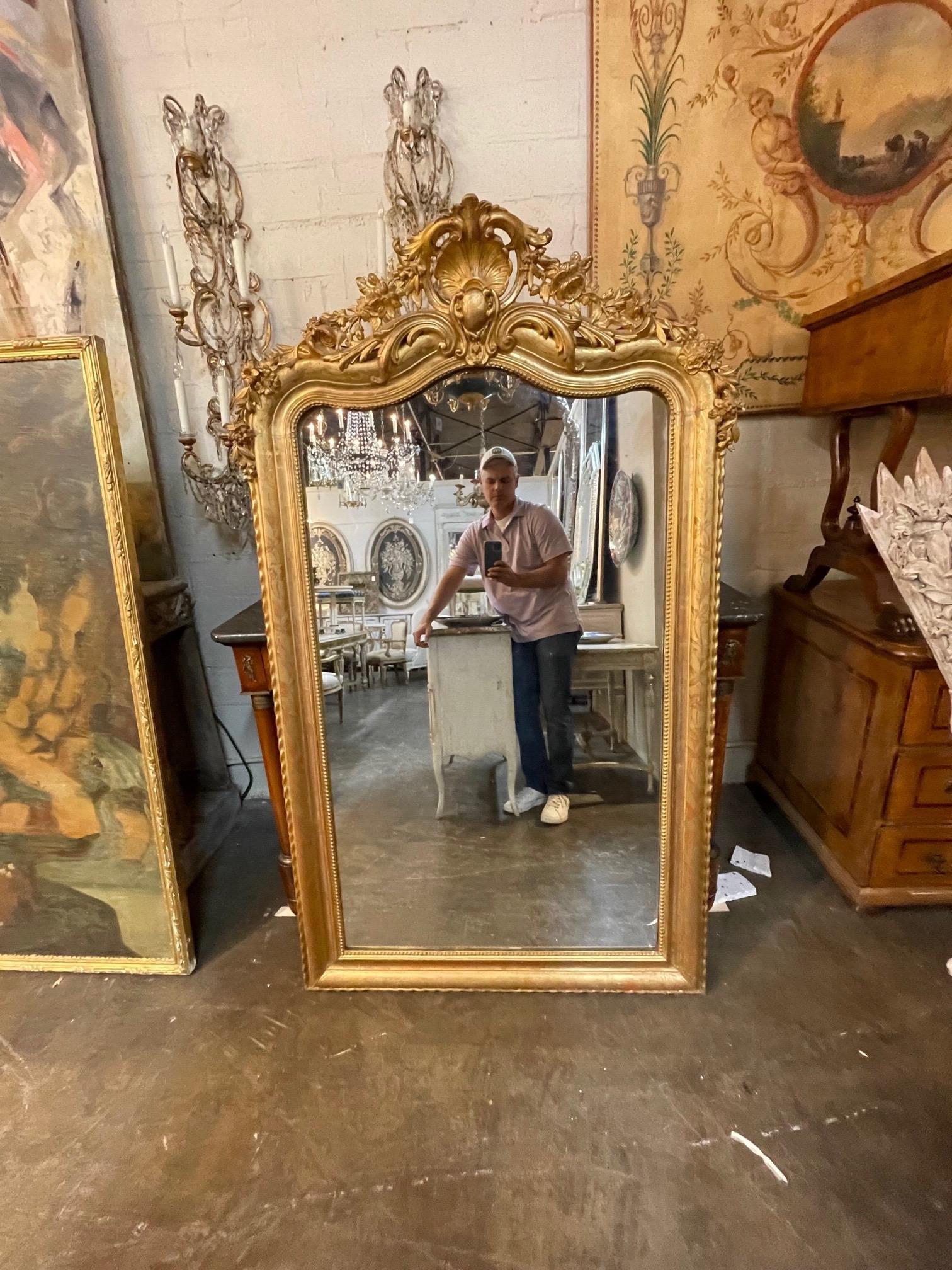 Lovely 19th century gold Louis Phillipe mirror. This piece has a beautiful patina as well as a beautiful crest and flowers at the top. Very elegant!!.