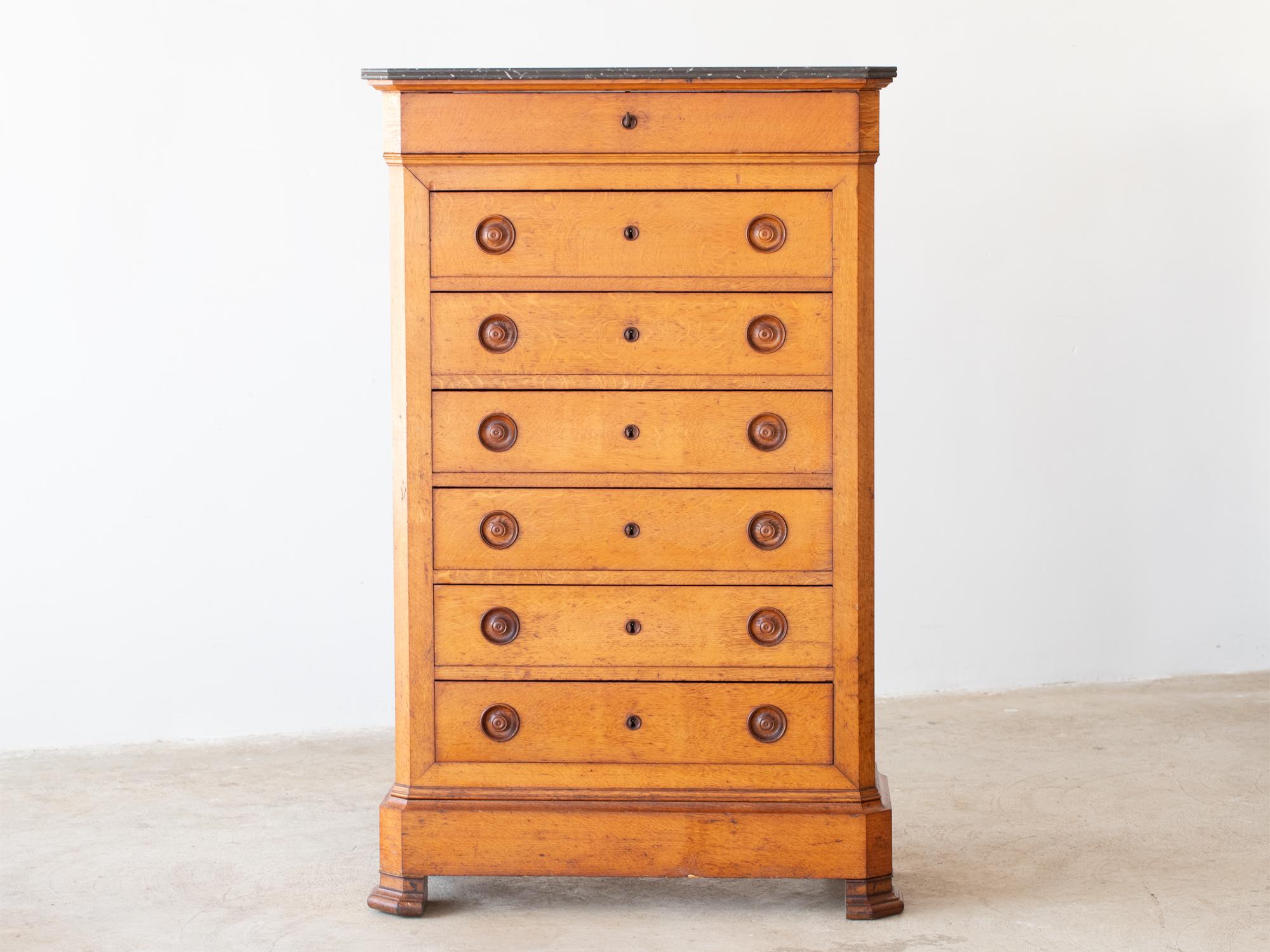 A Louis Philippe oak semainier or chest of seven drawers. French, c. 1840s.

In good sturdy order with wear consistent with age and use. Original black veined marble top and working locks with one shared key.

152 x 95 x 42 cm

59.8 x 37.4 x 16.5 