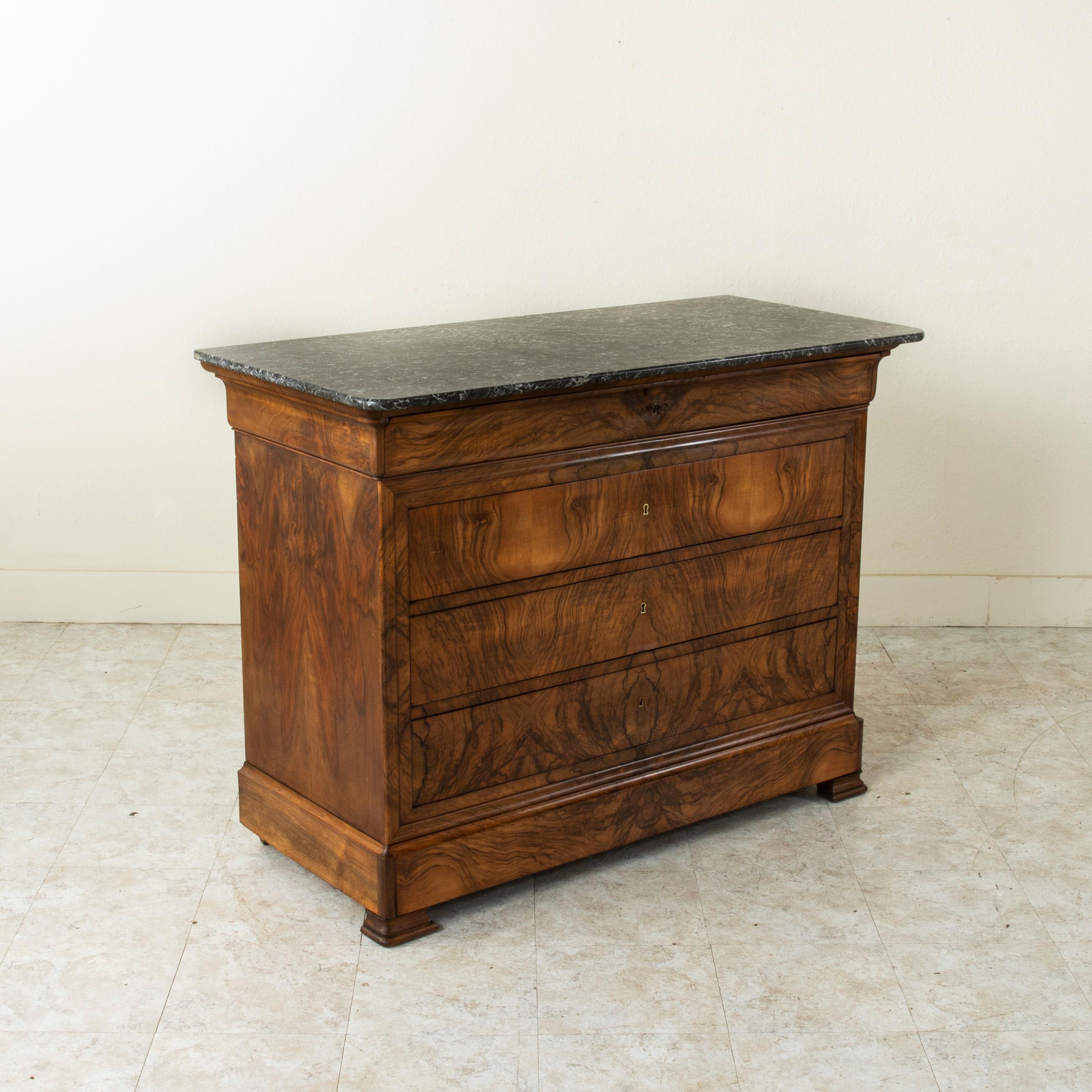 This quintessential Louis Philippe period commode or chest of drawers displays the exemplary craftsmanship of the early nineteenth century with an exterior of bookmatched burl walnut. A testament to the beauty of the wood, this piece is crowned by a