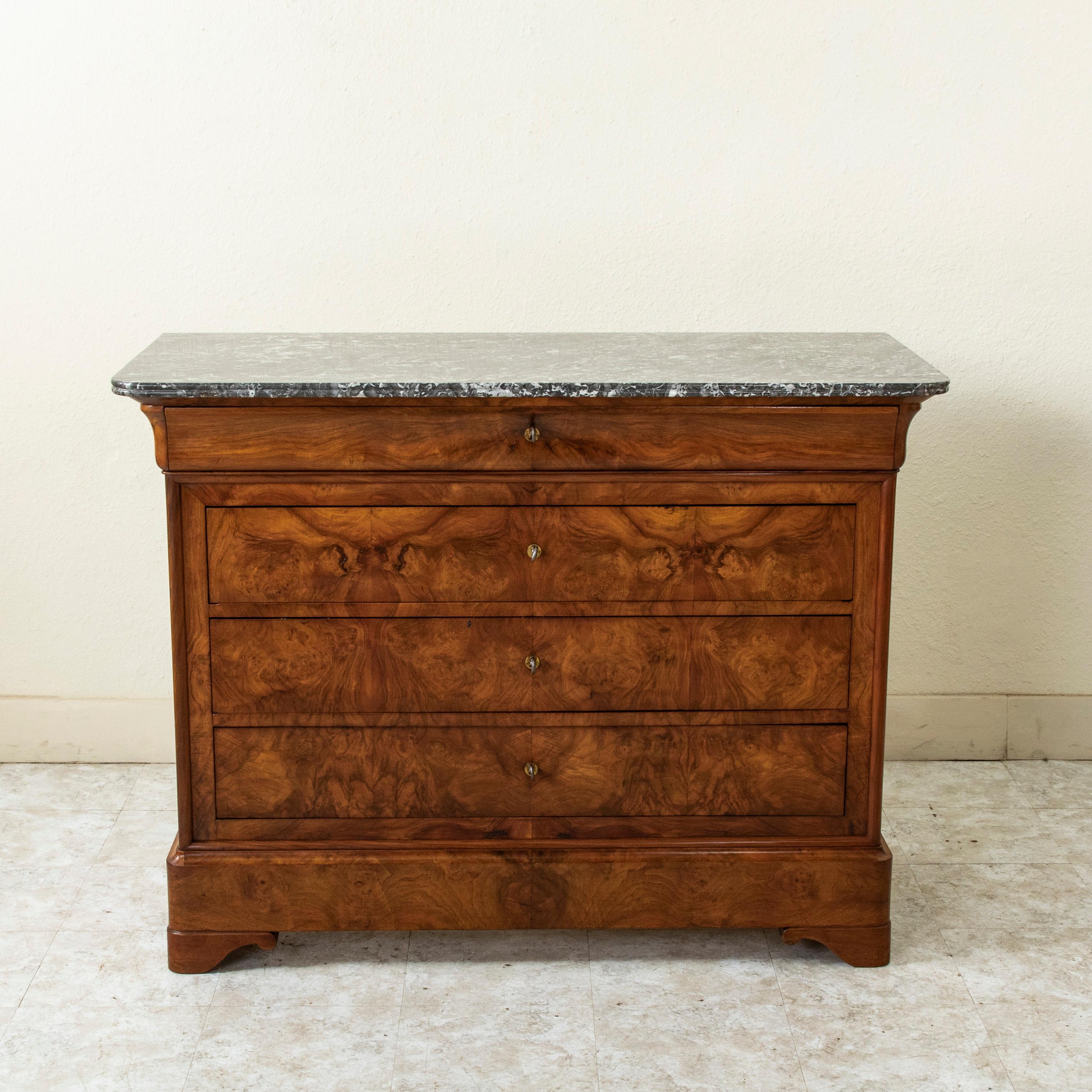 Questa commode o cassettiera in stile Louis Philippe mostra l'esemplare maestria artigianale del XIX secolo con una facciata in noce abbinato e fianchi con pannelli in noce massiccio. Il pezzo è sormontato da un piano in marmo Saint Anne a doppio