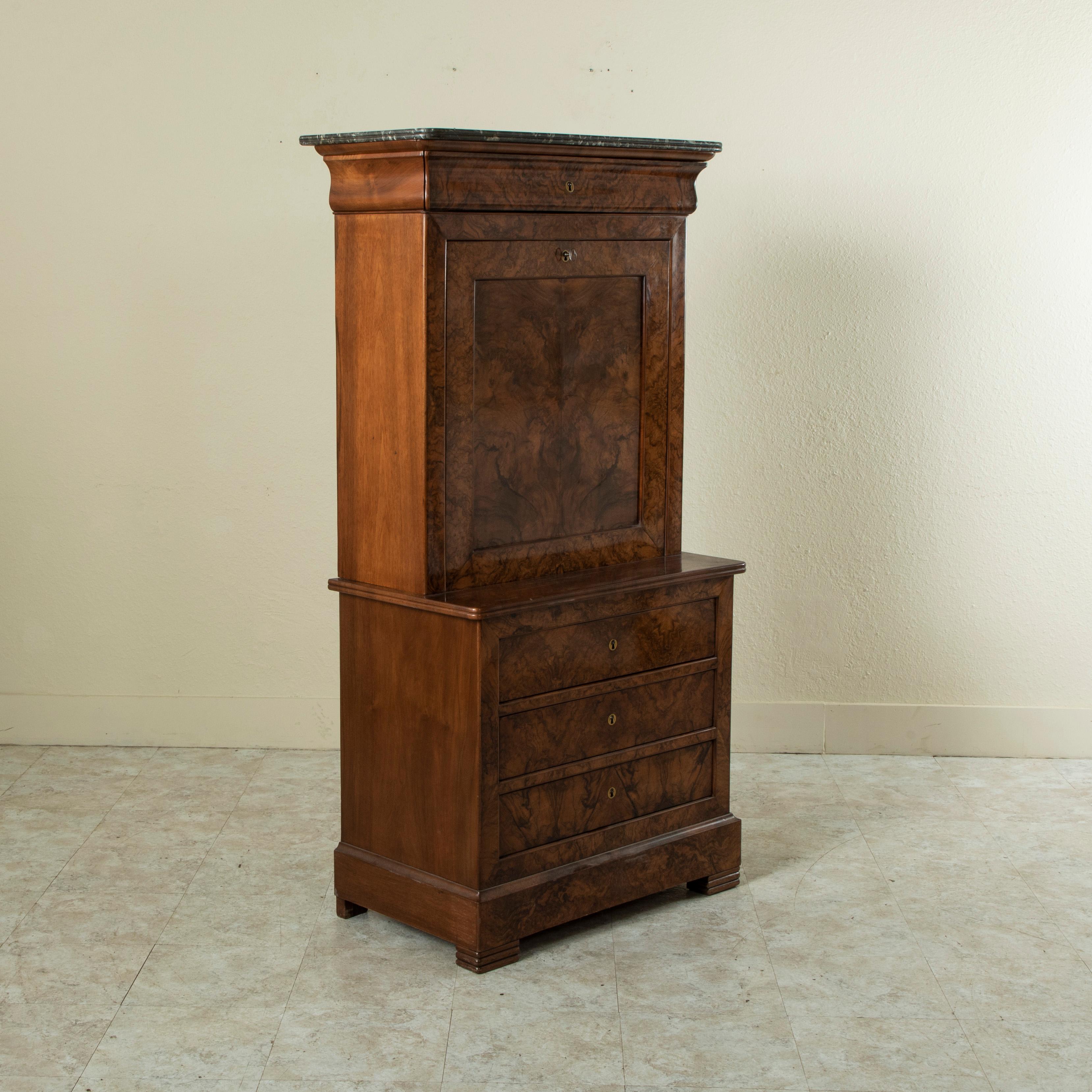 This nineteenth century Louis Philippe period secretary features an exquisite book matched burl walnut façade, an aesthetic that came to the forefront later during the Louis Philippe period of the 1830s. Its drop down front opens to reveal a tooled