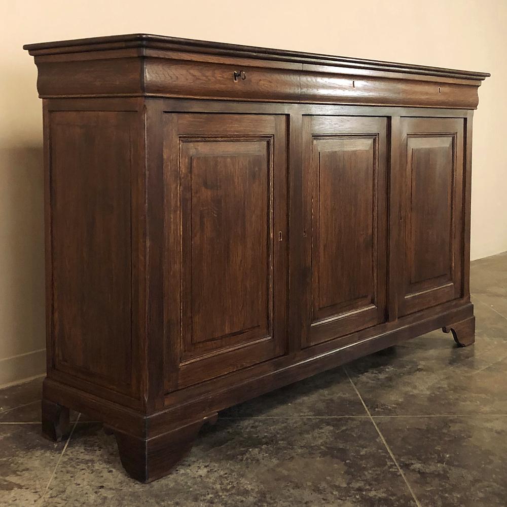 19th century French Louis Philippe period buffet was fashioned from indigenous old-growth oak to emulate the styles in vogue at the courts of the time. After the French Revolution, a few brief monarchies reigned, and the style they dictated was
