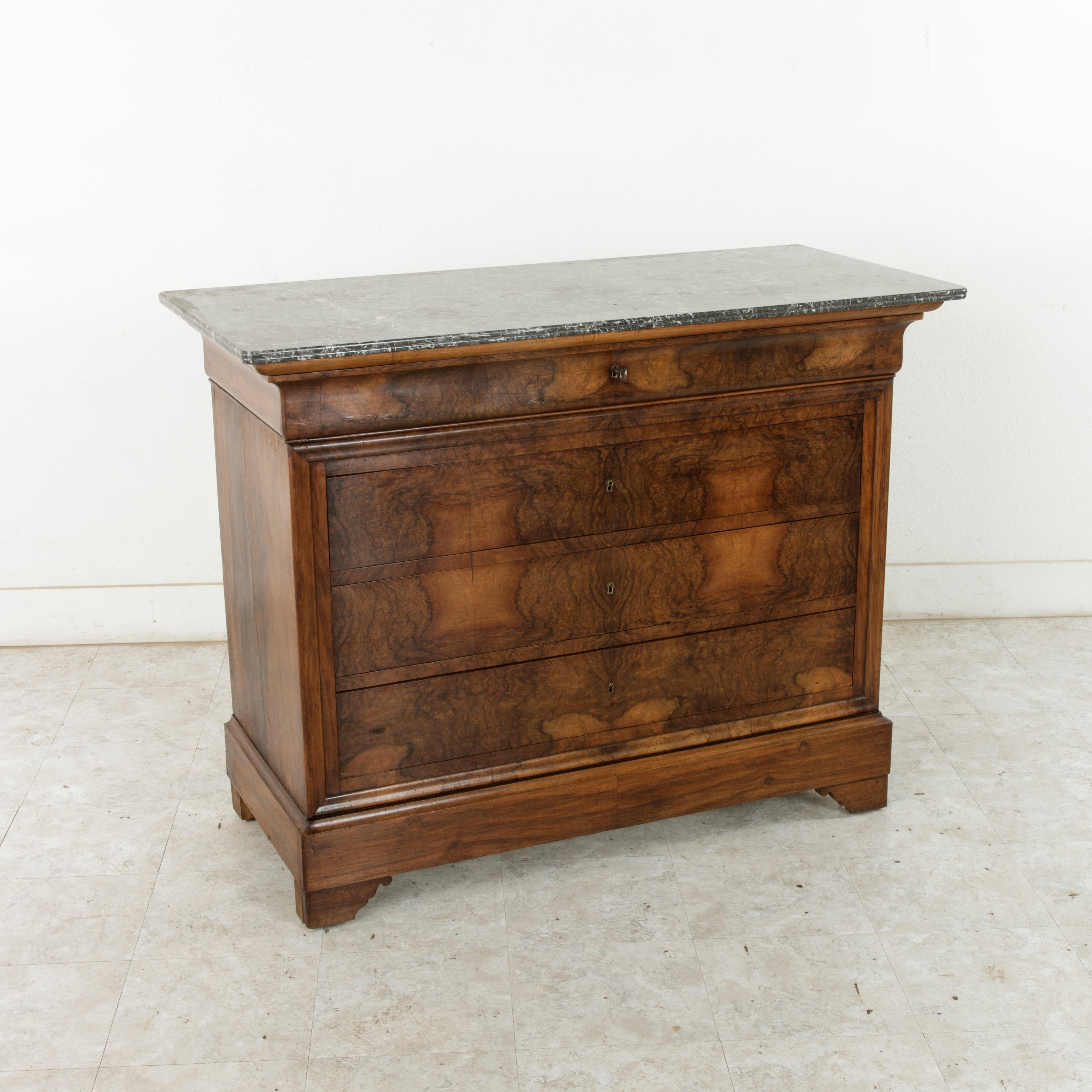 This quintessential Louis Philippe period commode or chest of drawers displays the exemplary craftsmanship of the early nineteenth century with a facade of bookmatched burl walnut and solid walnut panel sides. A testament to the beauty of the wood,