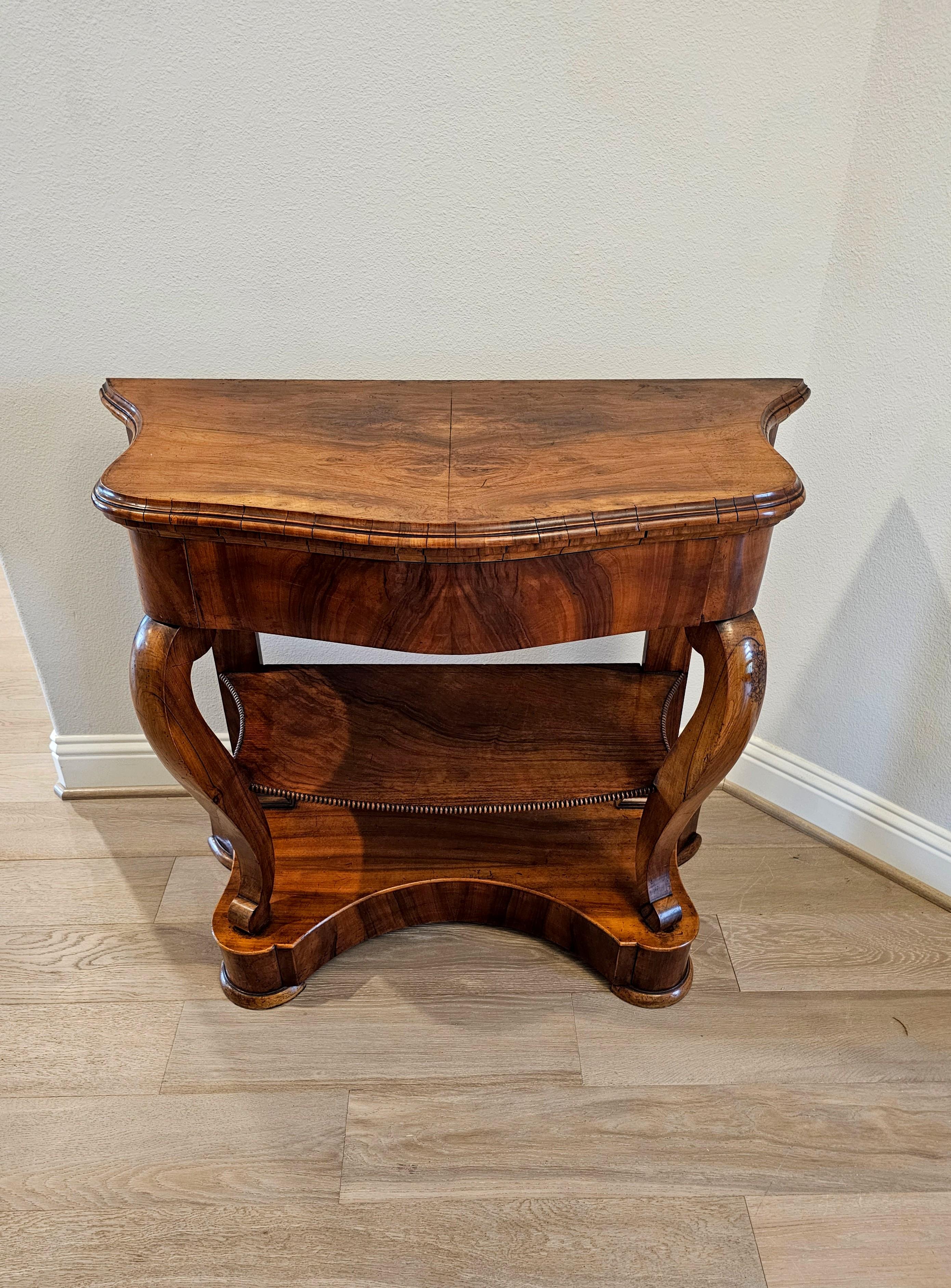 A nearly 200 year old Period Louis Philippe (1830-1848) French burled walnut tiered console table.

Born in France in the mid-19th century, hand-crafted of fine warm rich solid walnut, having a serpentine shaped bookmatched burlwood top with