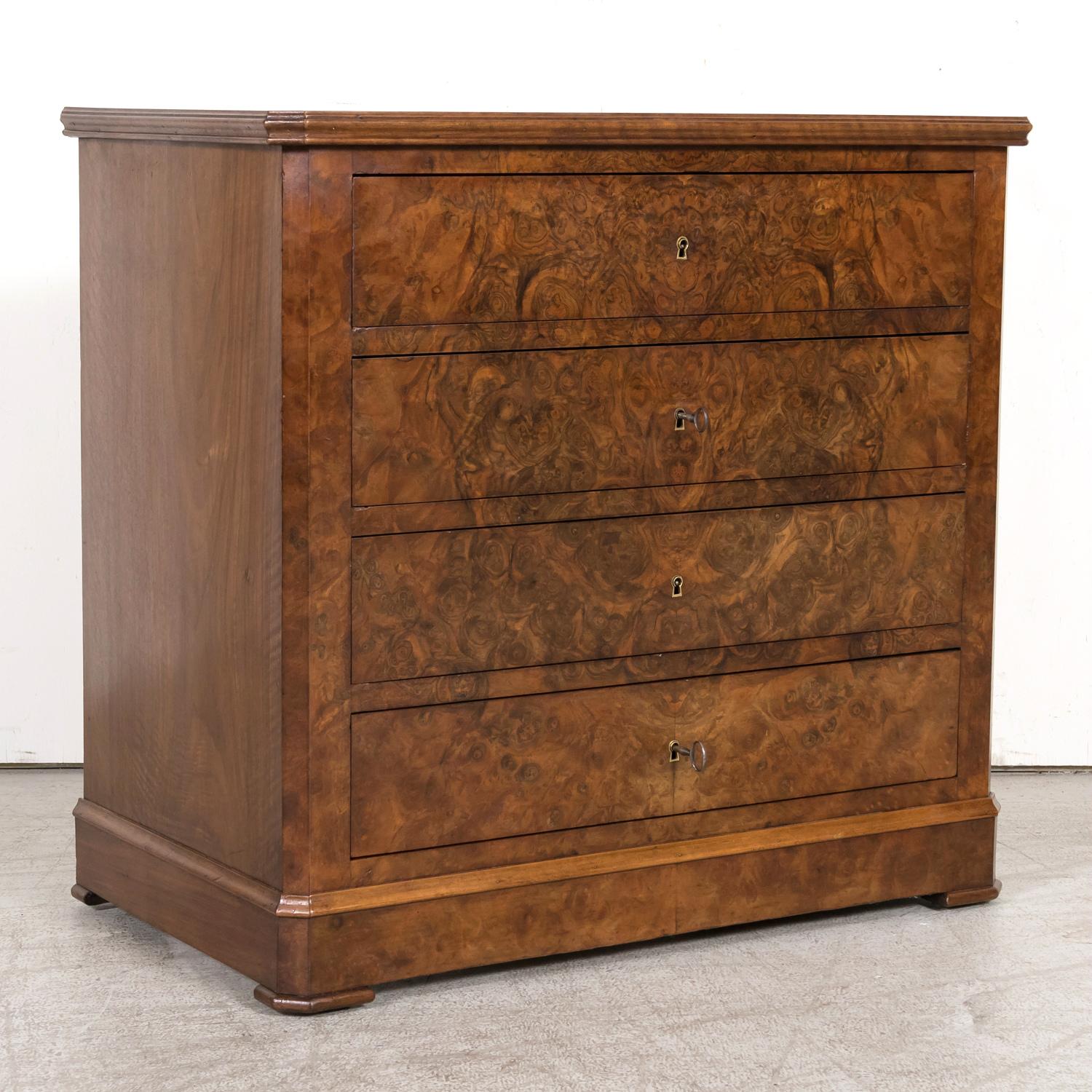 A fine 19th century French Louis Philippe period petite commode, circa 1850s, from Provence. Having an inset Carrara marble top, this handsome walnut antique French chest of drawers features a meticulously bookmatched burled walnut front with 4 full