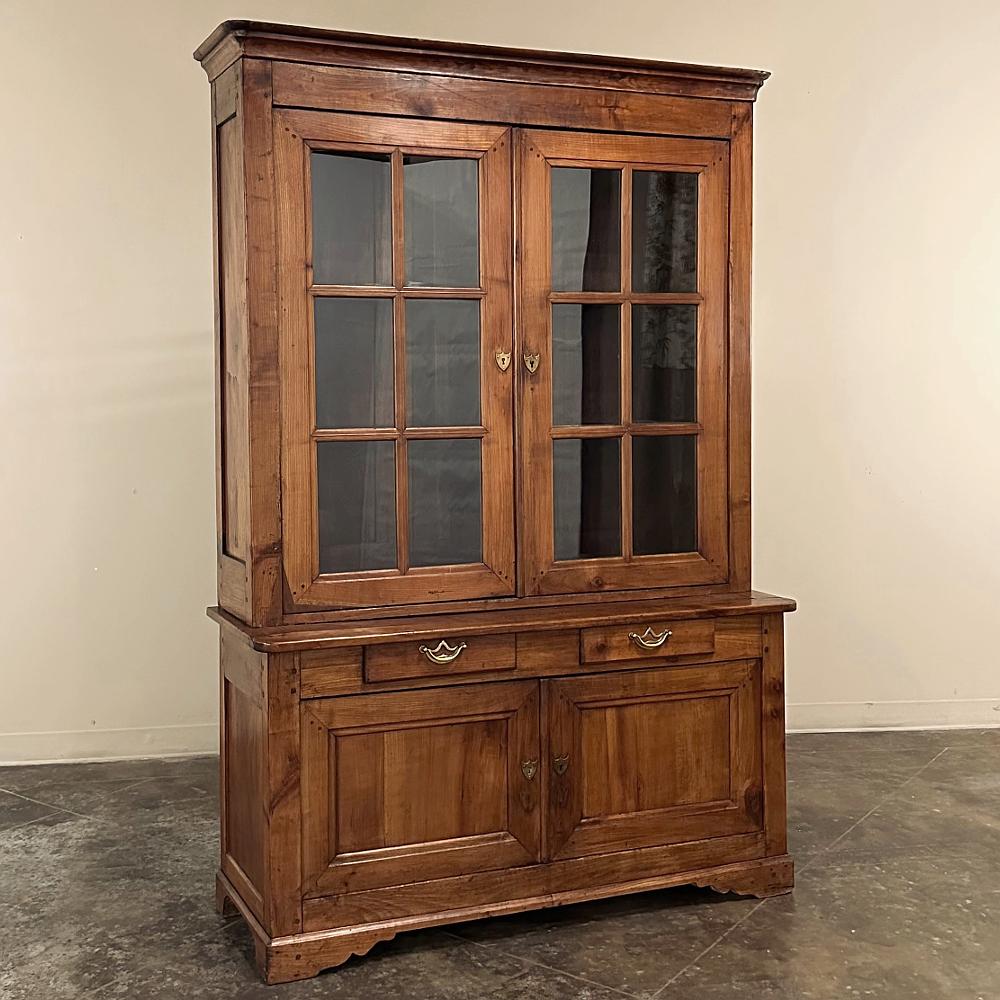 19th Century French Louis Philippe Period Cherry Bookcase ~ China Buffet is a timeless rendition of the genre, executed in beautifully aged cherry wood presenting a splendid figure and patina into the design.  The stately, austere architecture of