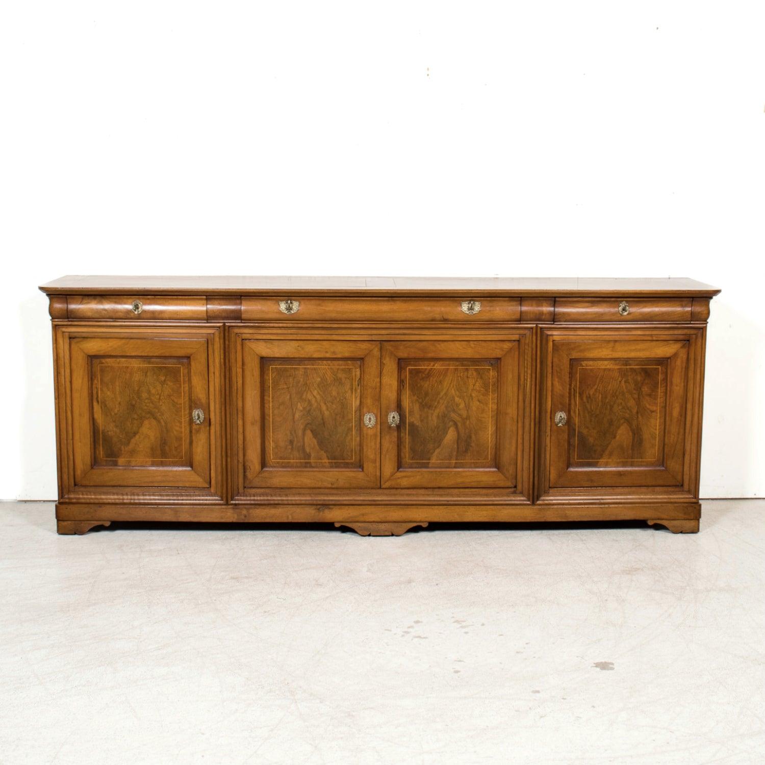 Exemple raffiné de l'élégance provinciale française, ce buffet d'enfilade en merisier d'époque Louis Philippe a été fabriqué à la main à Lyon, vers les années 1830. Réputée au XIXe siècle pour ses guildes artistiques et ses ébénistes, Lyon a