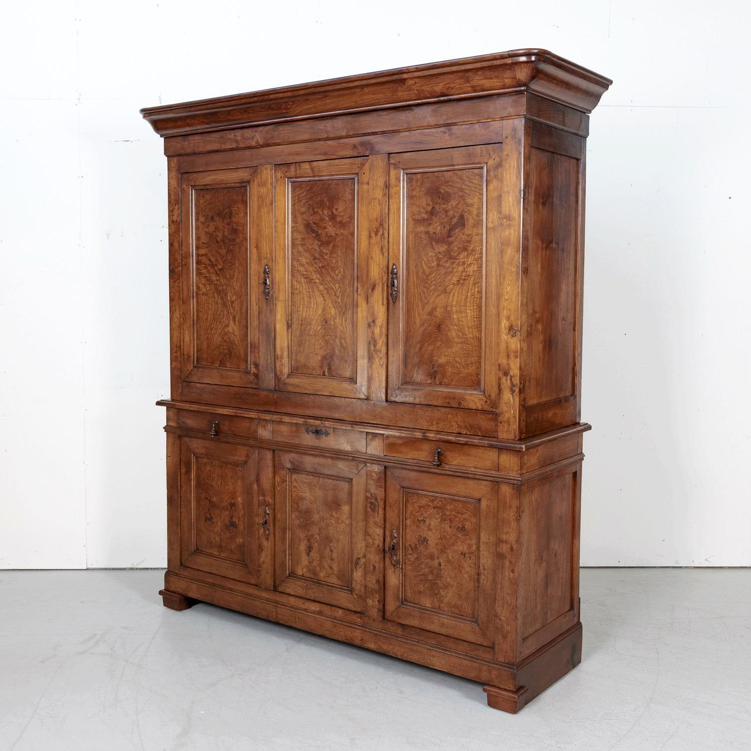 Large 19th century French Louis Philippe period buffet deux corps handcrafted of chestnut and burled chestnut, circa 1840s. The upper cabinet, having a doucine crown above three burled chestnut panel doors, opens to reveal an interior shelf with