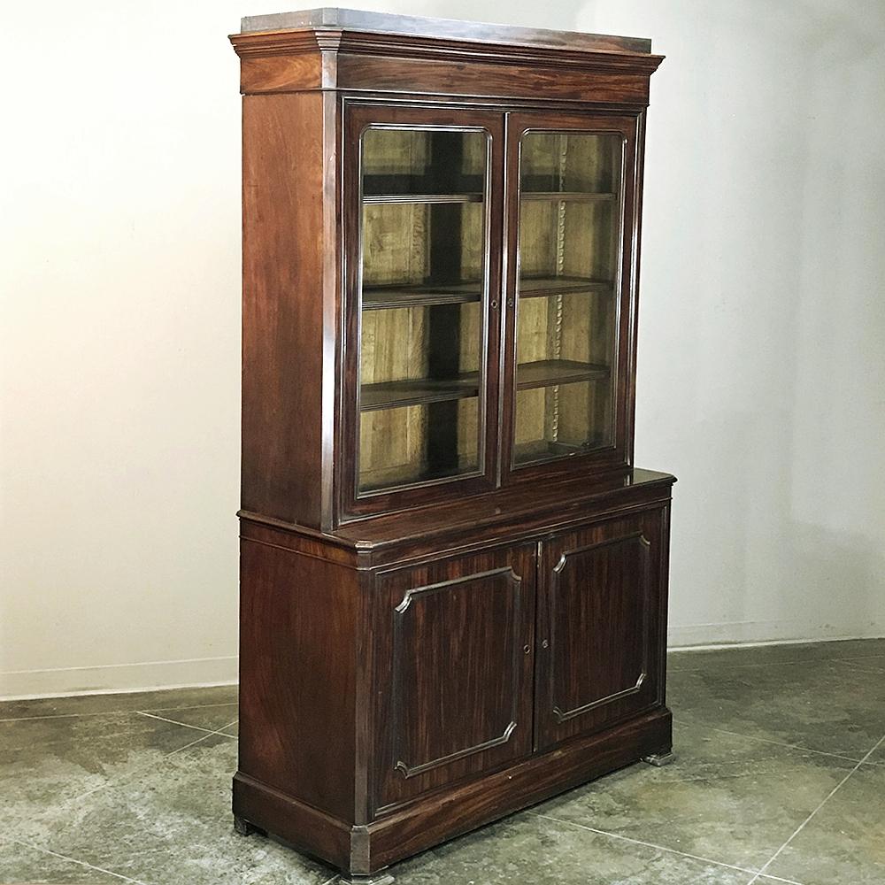 This handsome 19th century French mahogany Louis Philippe bookcase features glazed display above and cabinet storage below, all rendered from exotic imported mahogany which was considered the premier wood during the middle of the 19th century,