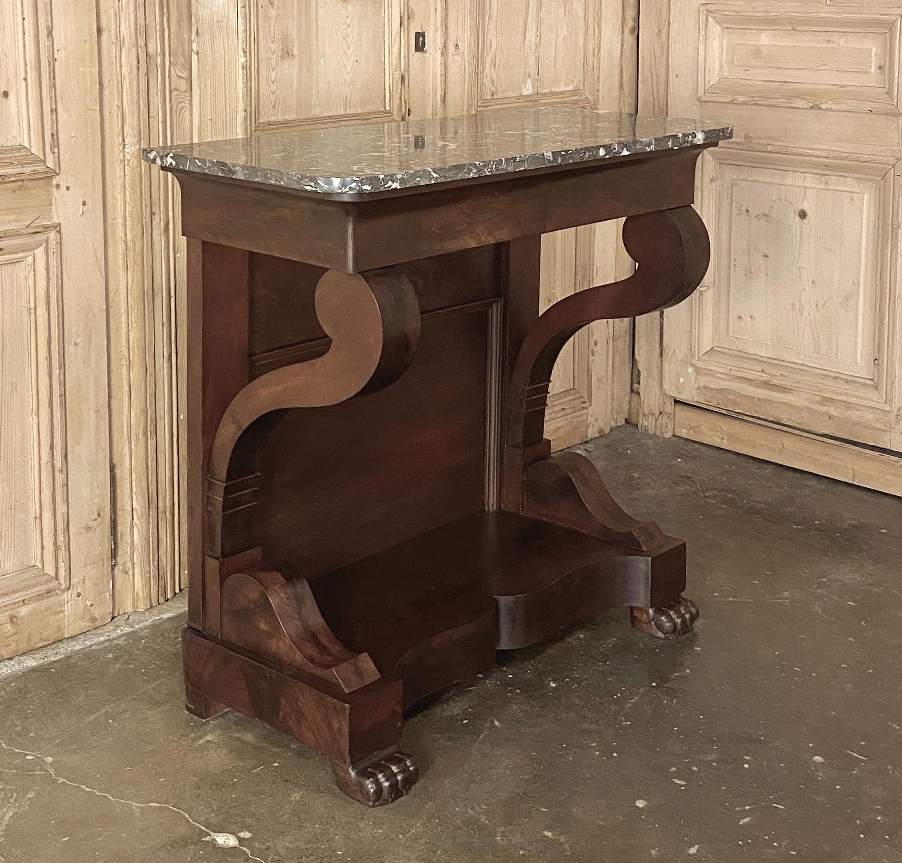 19th century French Louis Philippe Period mahogany marble top console represents the pinnacle of the form, with the sheer natural beauty of the exotic imported wood taking center stage in the tailored design. Gracefully scrolled legs lead down to a