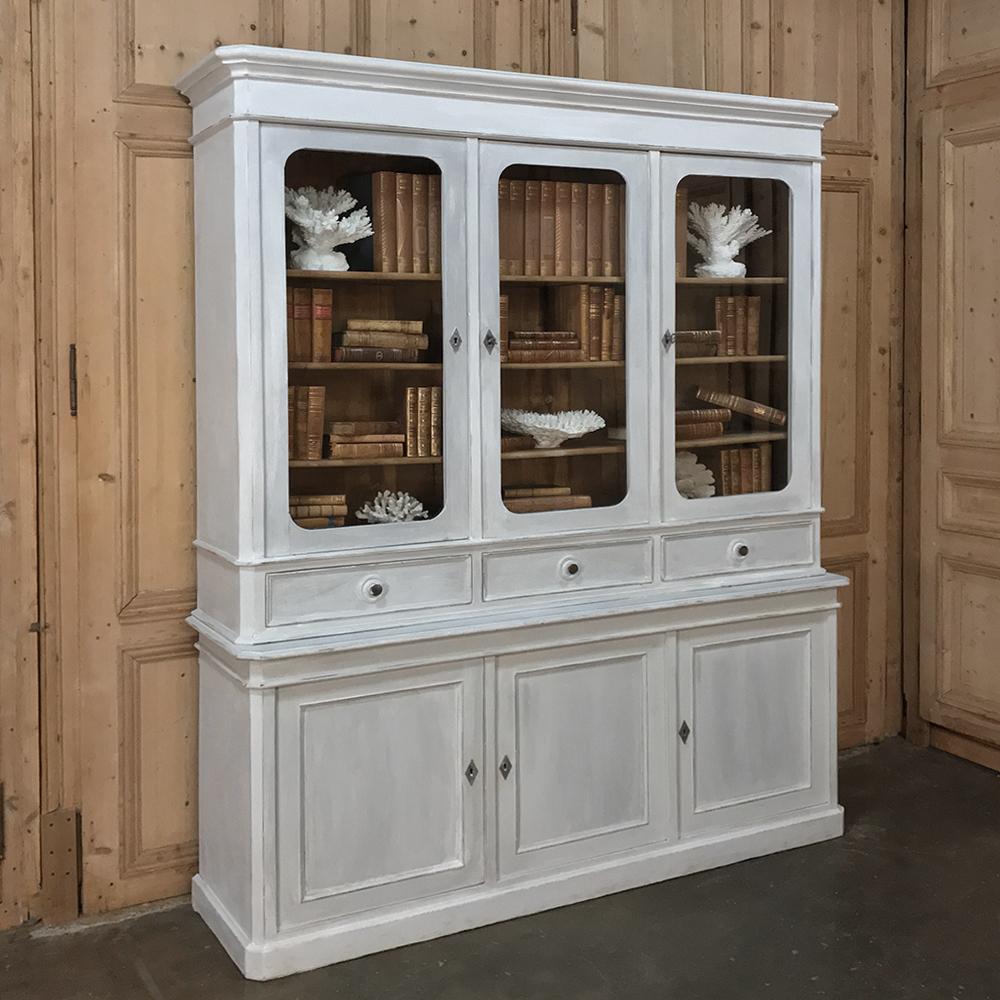 19th century French Louis Philippe period painted triple bookcase is a marvel of understated elegance! The style is known for its clean, tailored lines, and this wonderful example is no exception. Sporting three glazed cabinets above with three