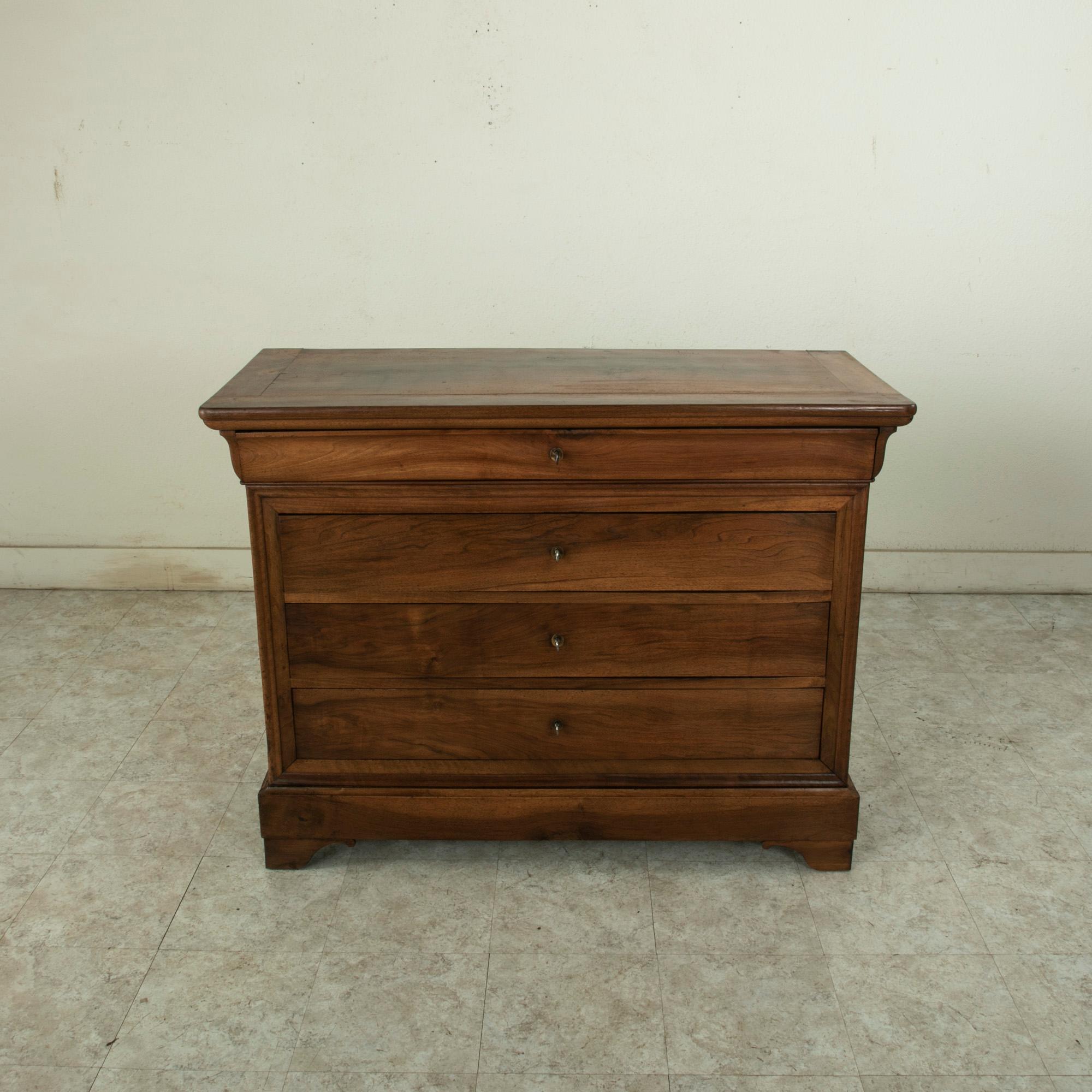 This nineteenth century French Louis Philippe period commode or chest of drawers is constructed of solid walnut. Its four drawers of dovetail construction each open using its key as a drawer pull. A handsome piece with clean simple lines, circa