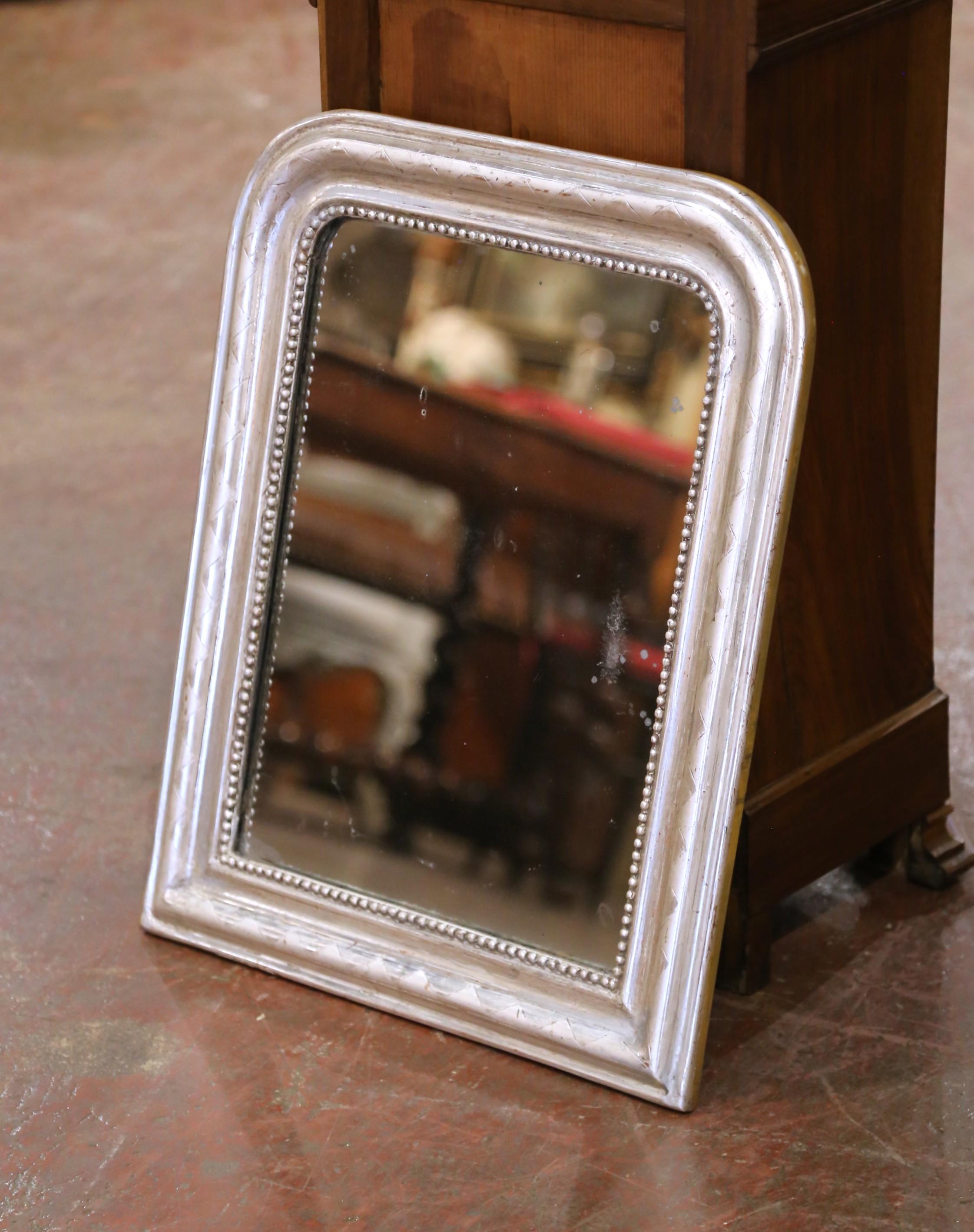 Enhance a powder room or hallway with this charming petite antique silvered mirror. Crafted in France circa 1870, the frame features the characteristic rounded top corners and clean, molded profile of the period, but with added detail, a prominent
