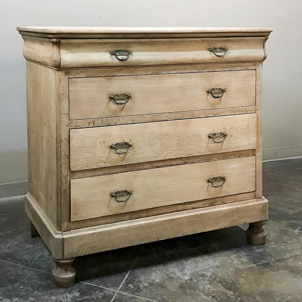 19th century French Louis Philippe stripped oak commode represents the tailored essence of the genre, with subtly curved drawer tier and straight, rectilinear architecture enhanced solely by brass drawer pulls. Handcrafted from solid oak in a