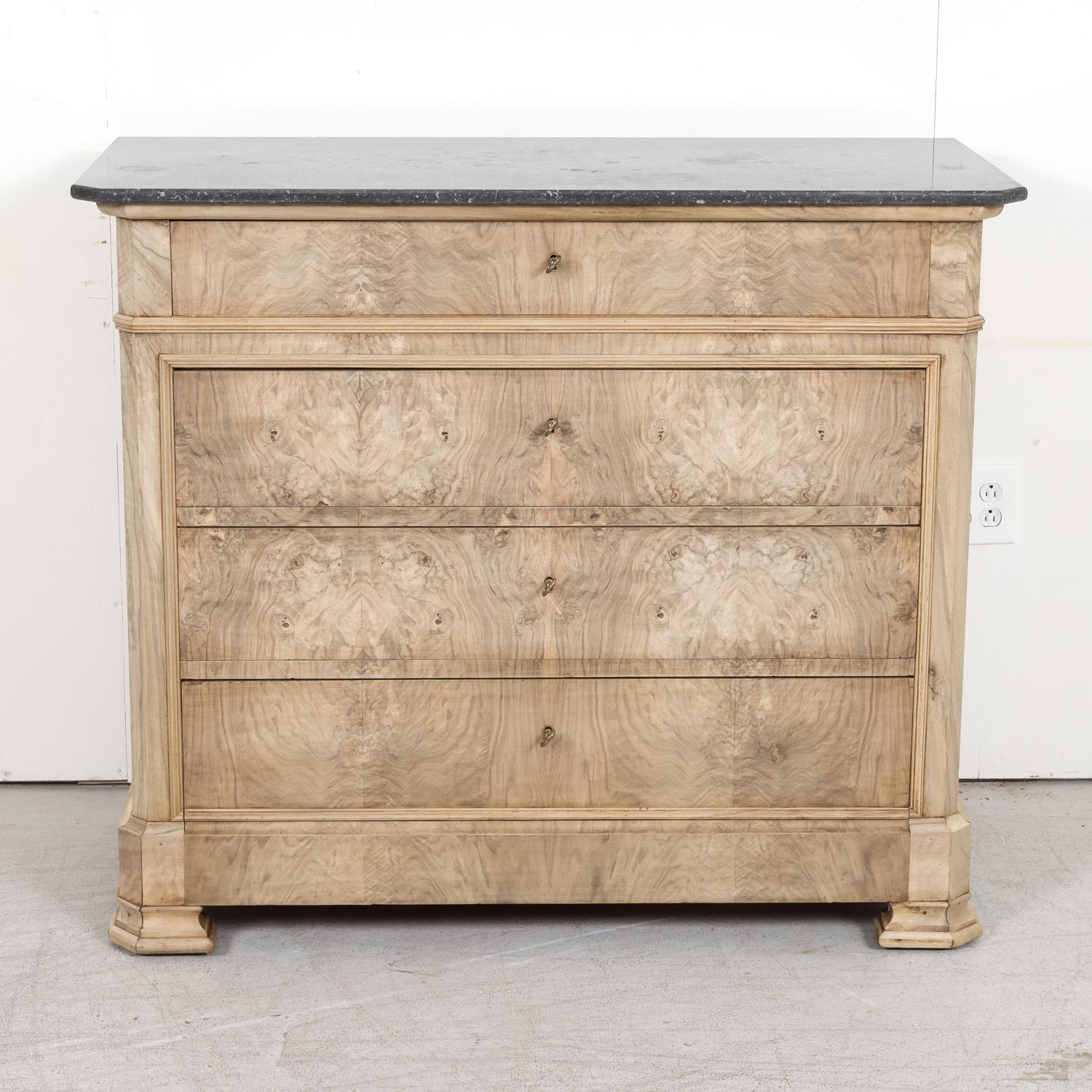 A handsome 19th century French Louis Philippe style four-drawer bleached commode handcrafted of walnut with a meticulously bookmatched burled walnut front by skilled artisans in the South of France near Avignon, circa 1880s. This striking commode