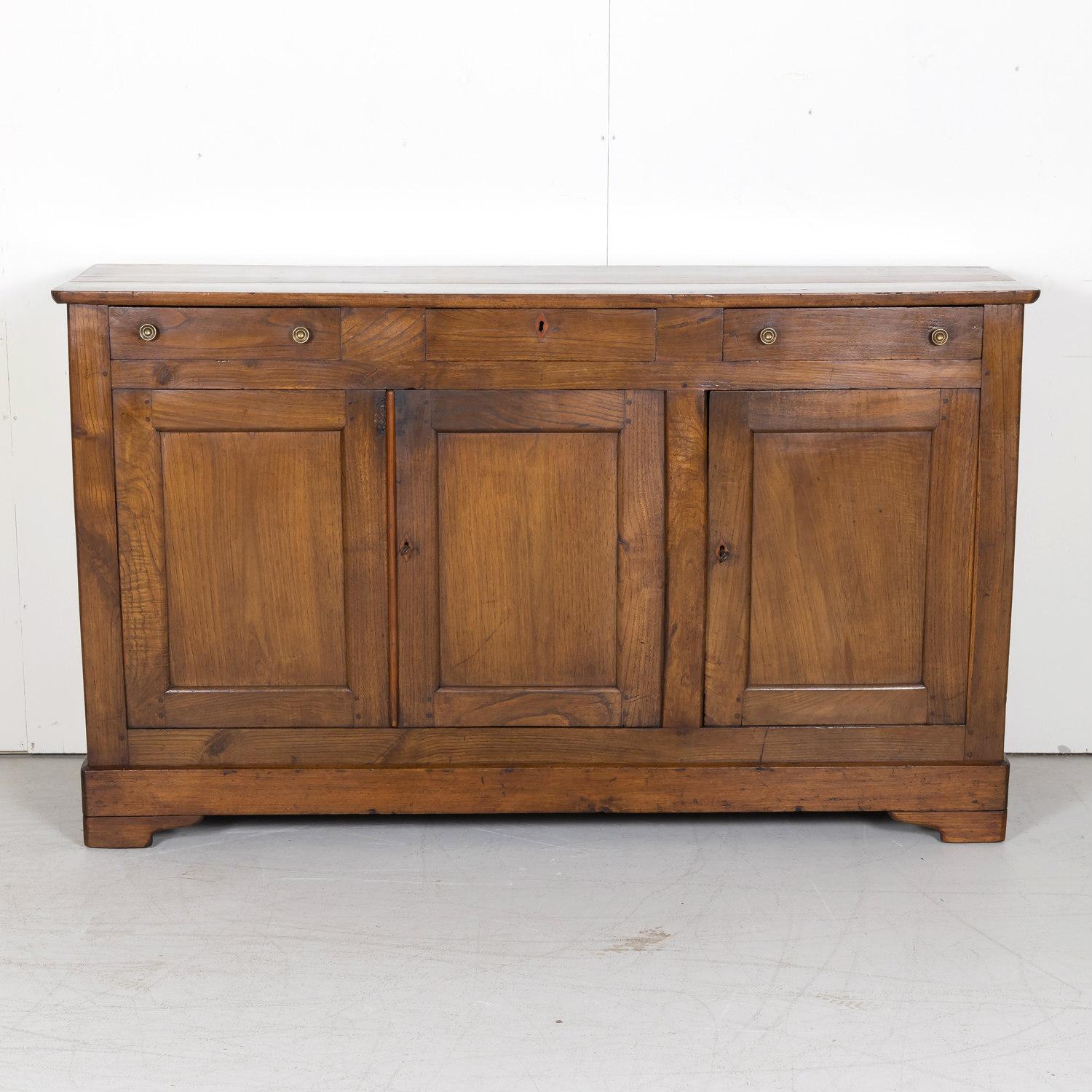 A 19th century French Louis Philippe style enfilade buffet d'appui or gentleman's buffet handcrafted of solid walnut and chestnut by skilled craftsmen near Bayeux, a town on the Aure river in the Normandy region of northwestern France, circa 1880s.